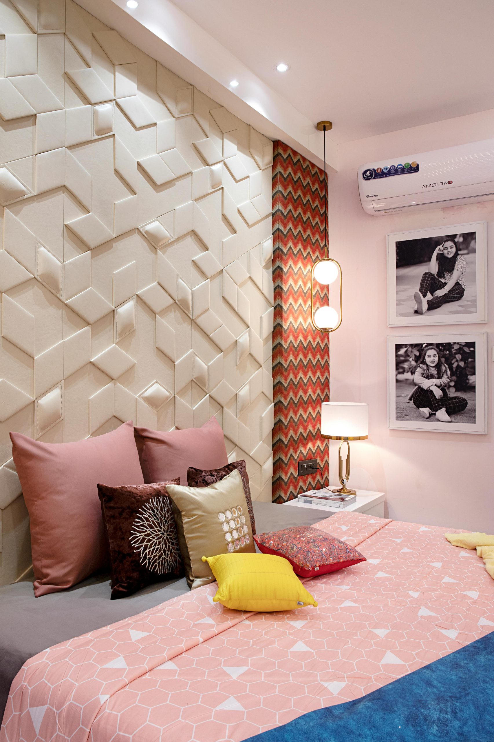 Stylish bedroom with geometric wall design and colorful pillows.