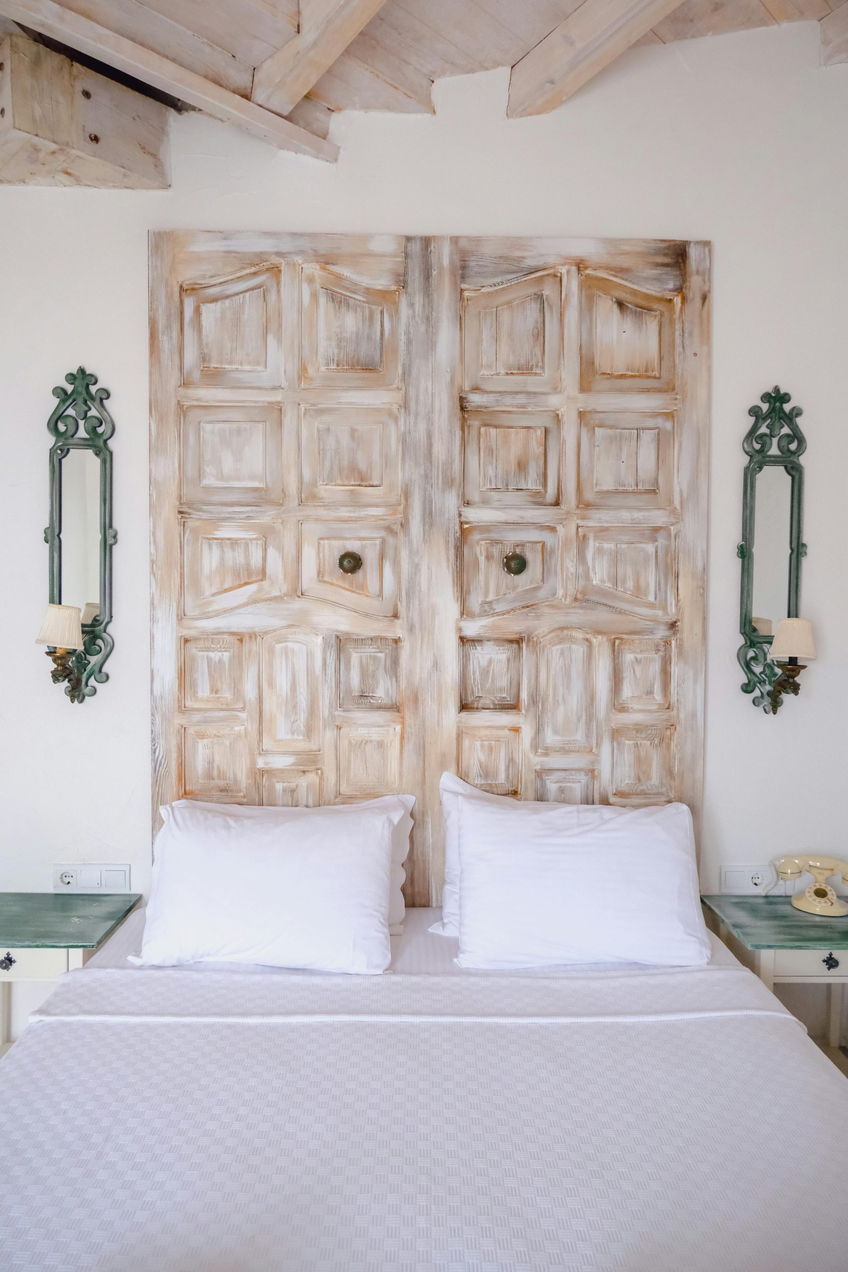 Stylish rustic bedroom with wooden headboard and elegant decor, creating a cozy ambiance.