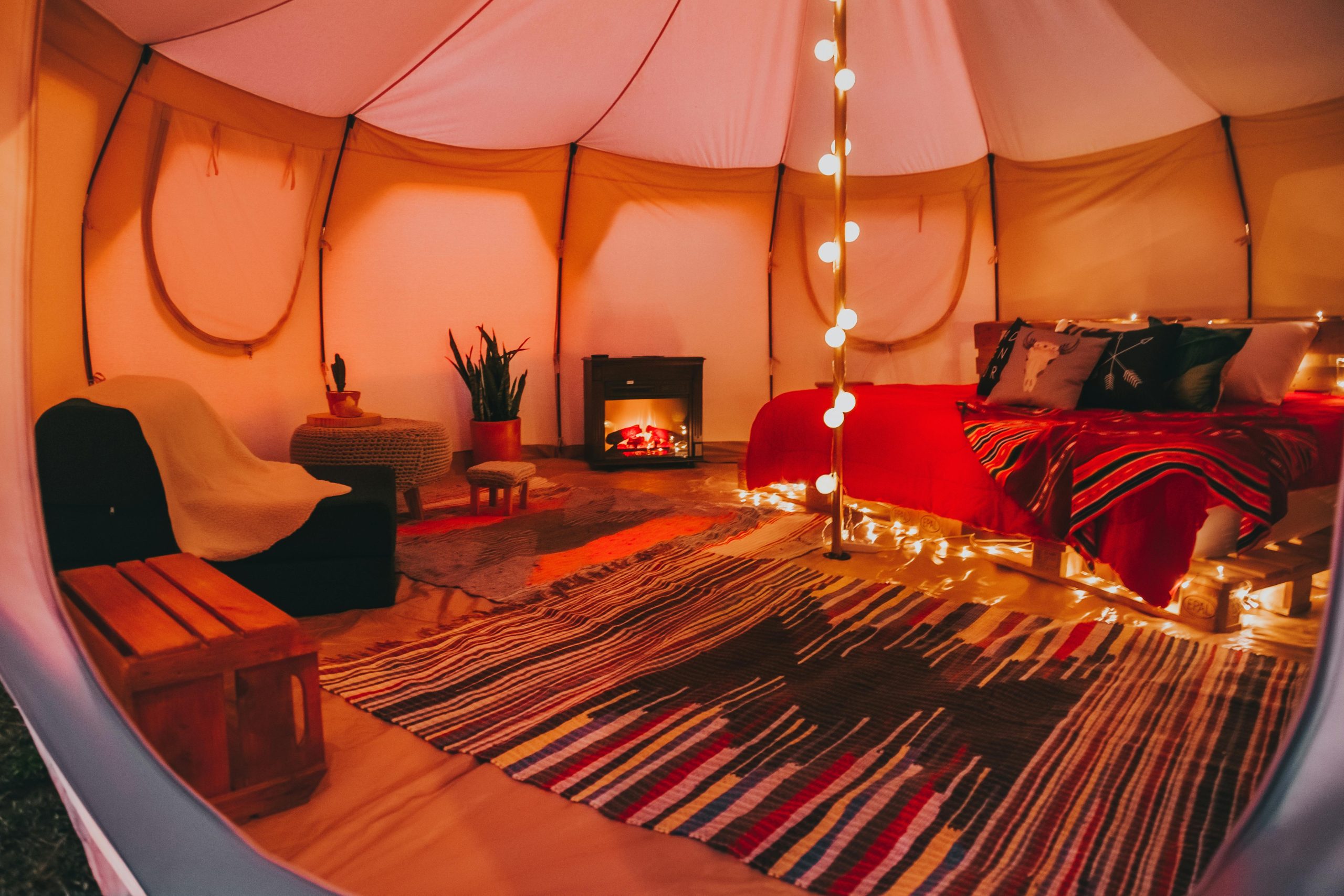 Warm and inviting tent interior design with cozy lighting and plush decor.