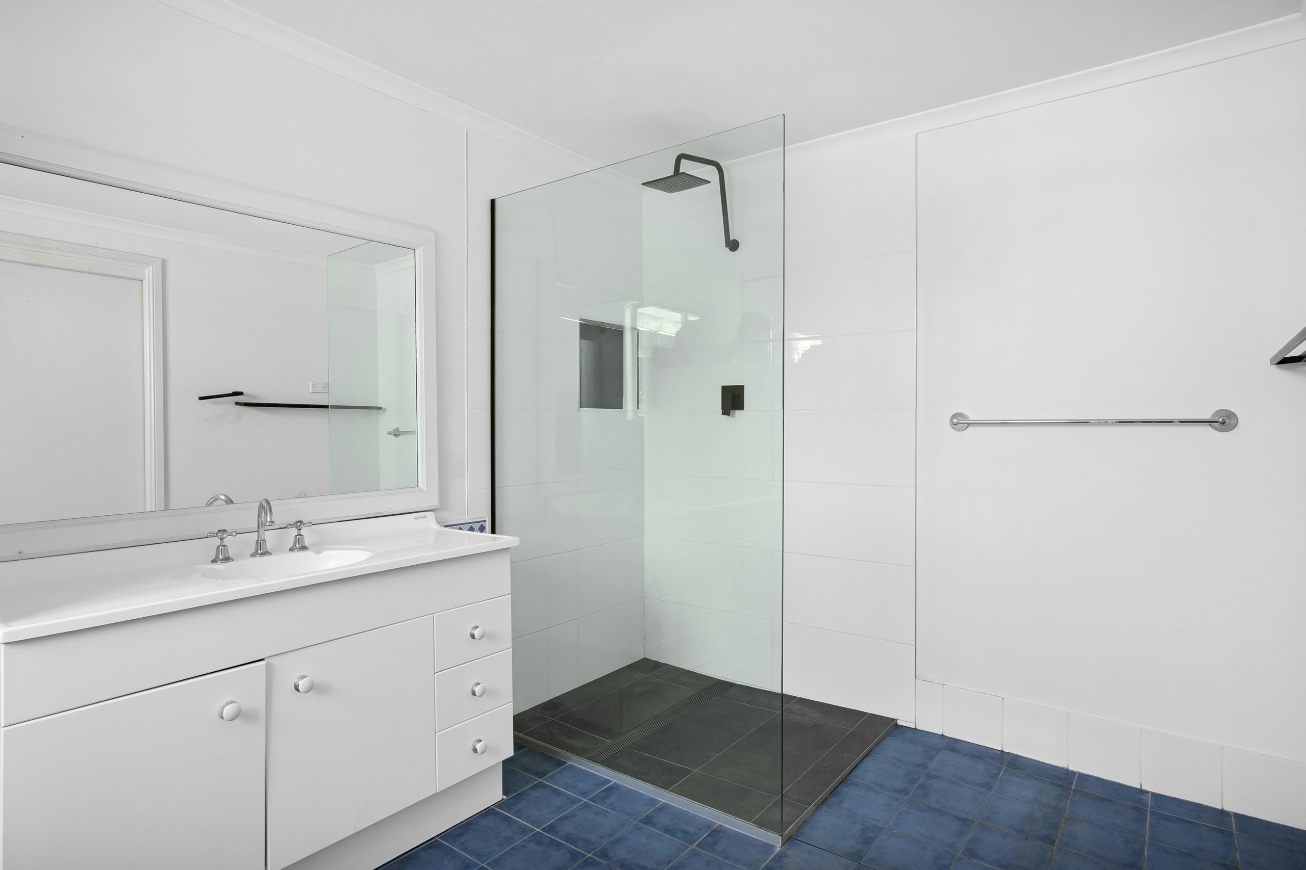 A bathroom with a sink, shower, and toilet