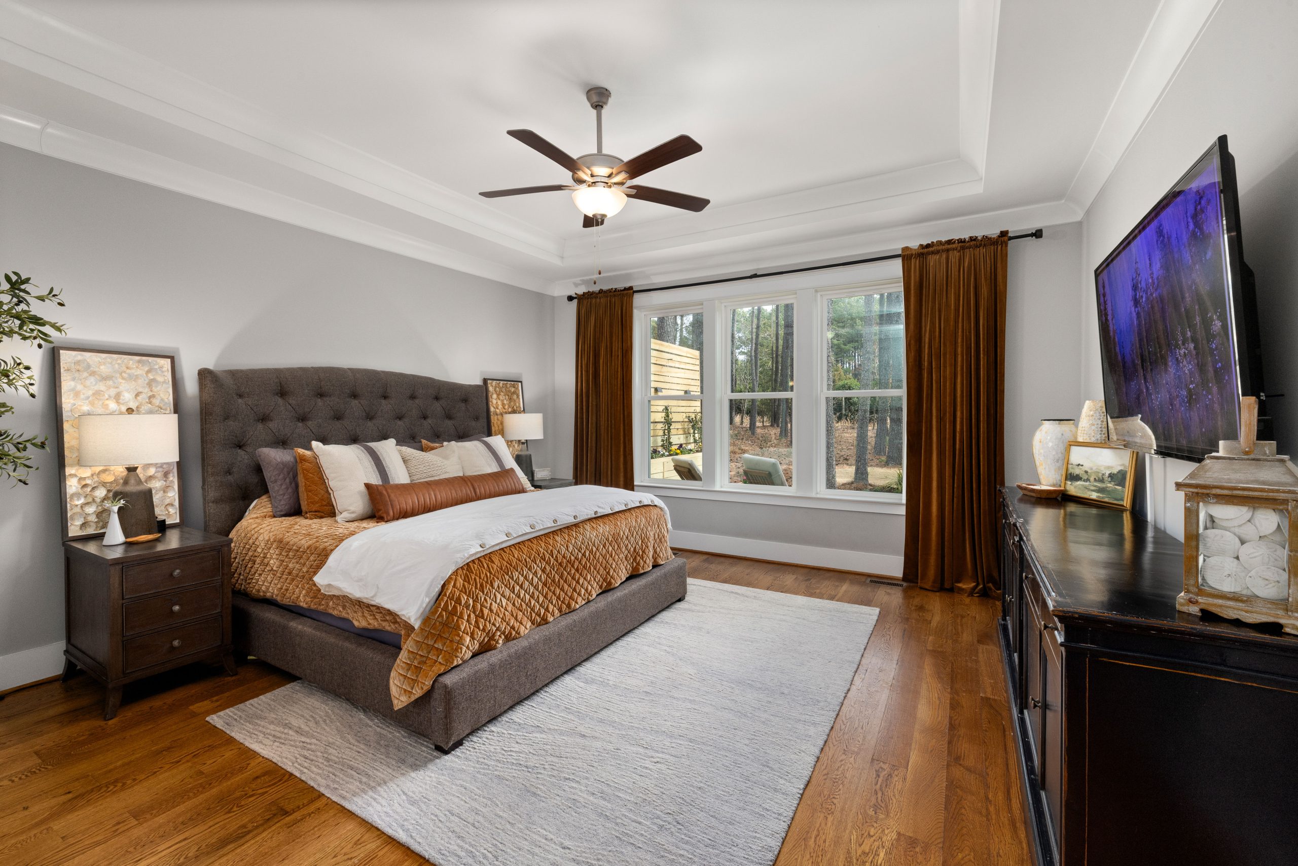 A beautifully decorated bedroom featuring modern furniture and warm earth tones.