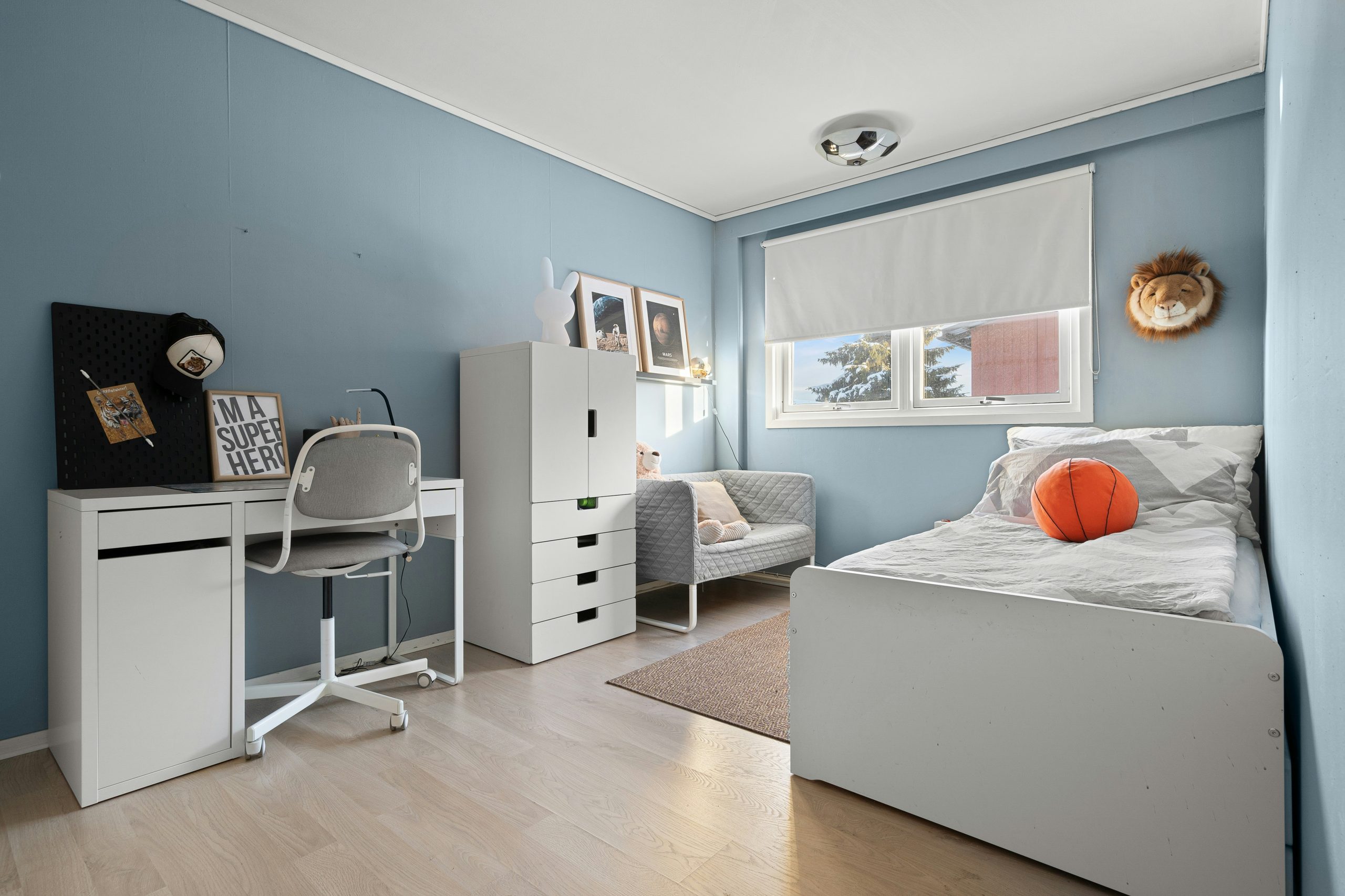 A bedroom with blue walls and white furniture