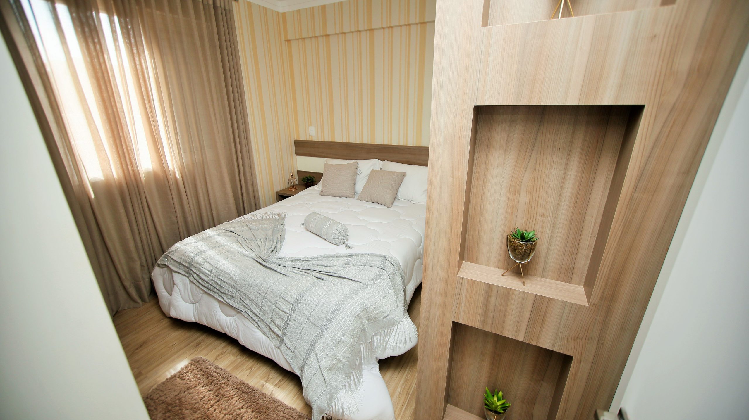A cozy modern bedroom with neutral tones, soft lighting, and stylish decor for a relaxing ambiance.