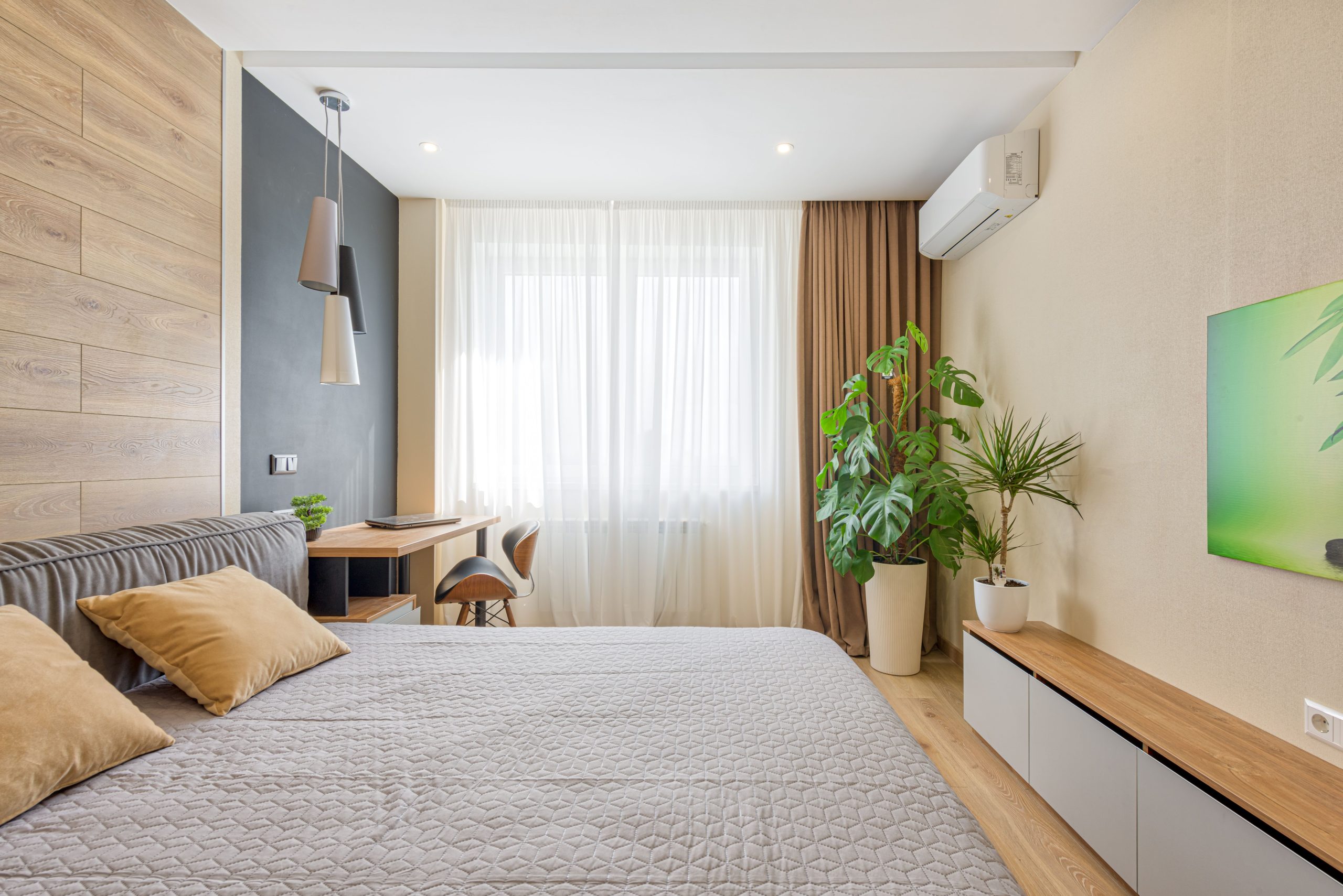 A modern bedroom featuring cozy decor, natural light, and indoor plants.