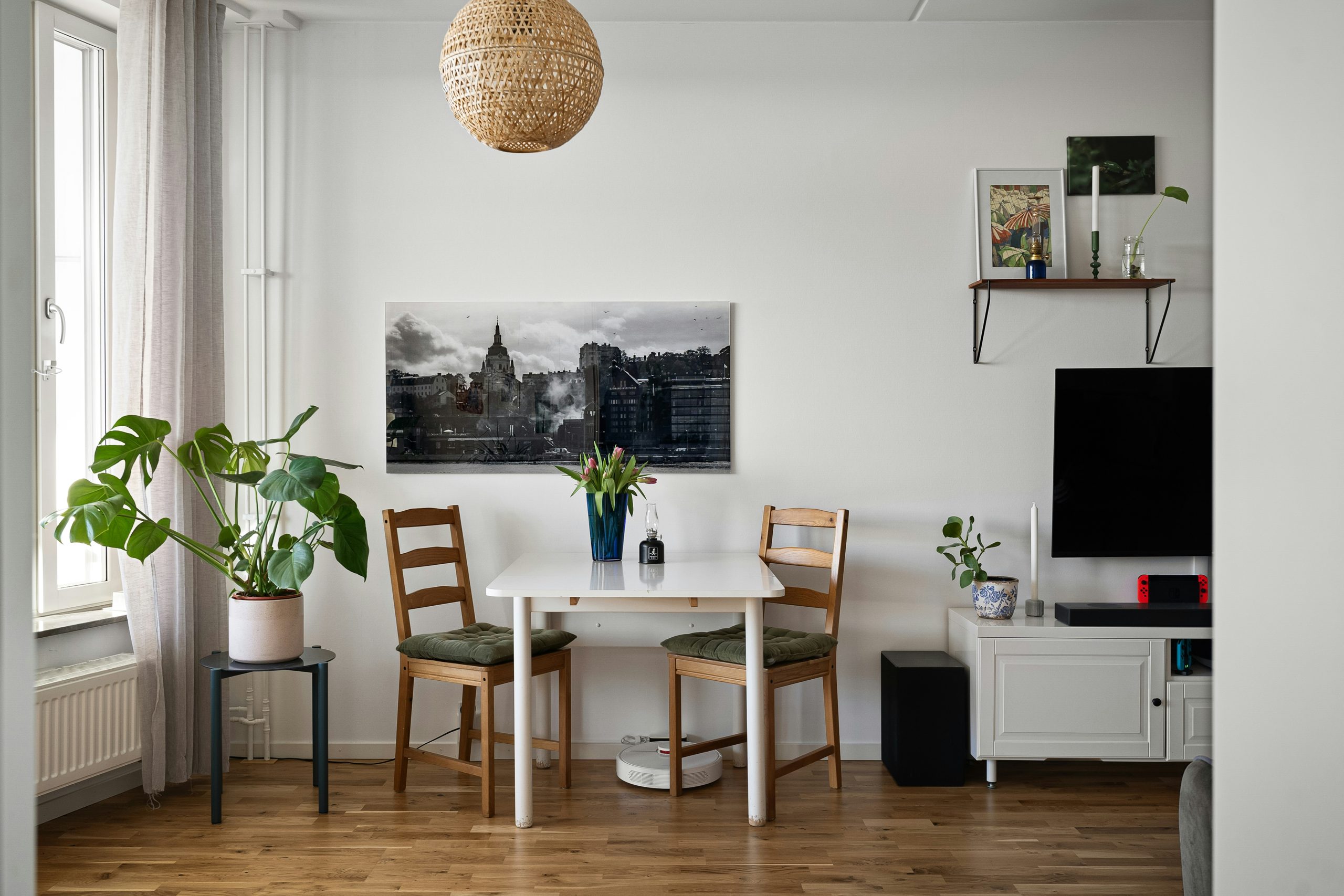 A room with a table, chairs and a television