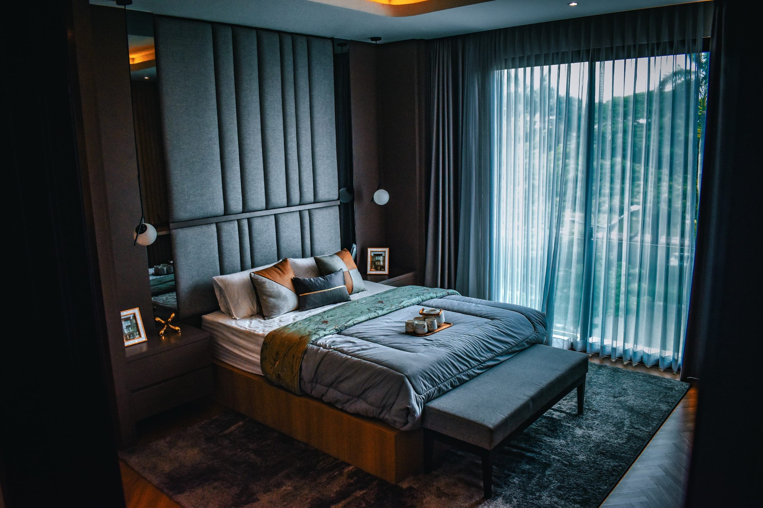 A spacious, modern bedroom with elegant decor and a large window.