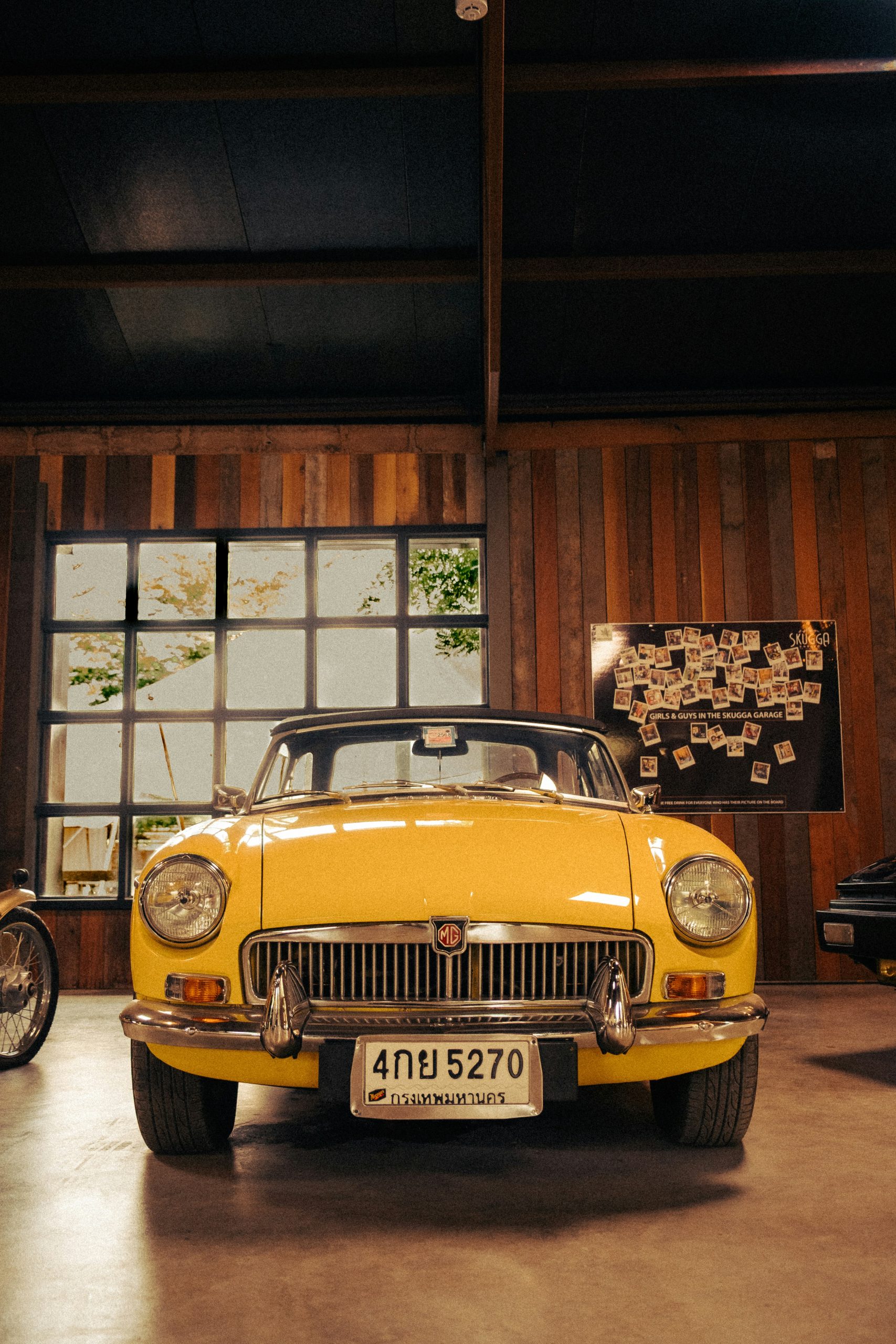 A vintage yellow convertible car parked indoors.