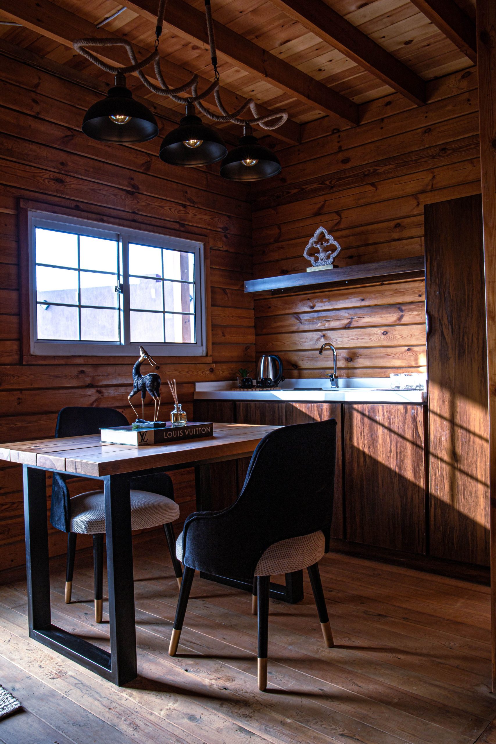A warmly lit rustic kitchen interior in a wooden cabin showcases thoughtful design with modern touches.