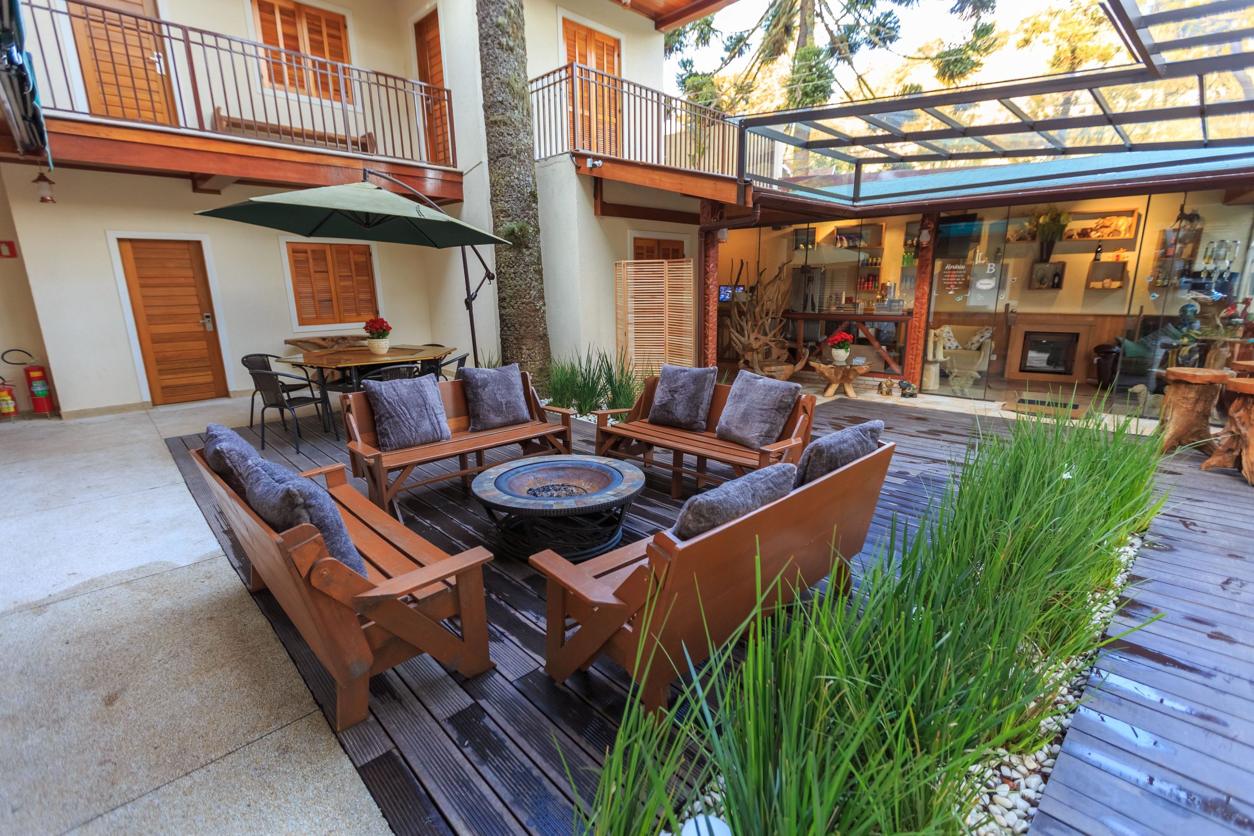 A welcoming outdoor patio with wooden furniture and lush plants in a modern residential courtyard.