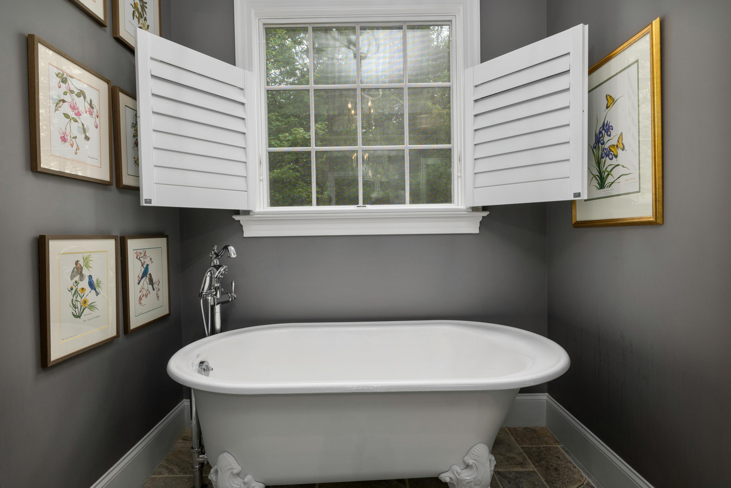 An elegant home interior featuring a classic freestanding bathtub and decorative wall art.