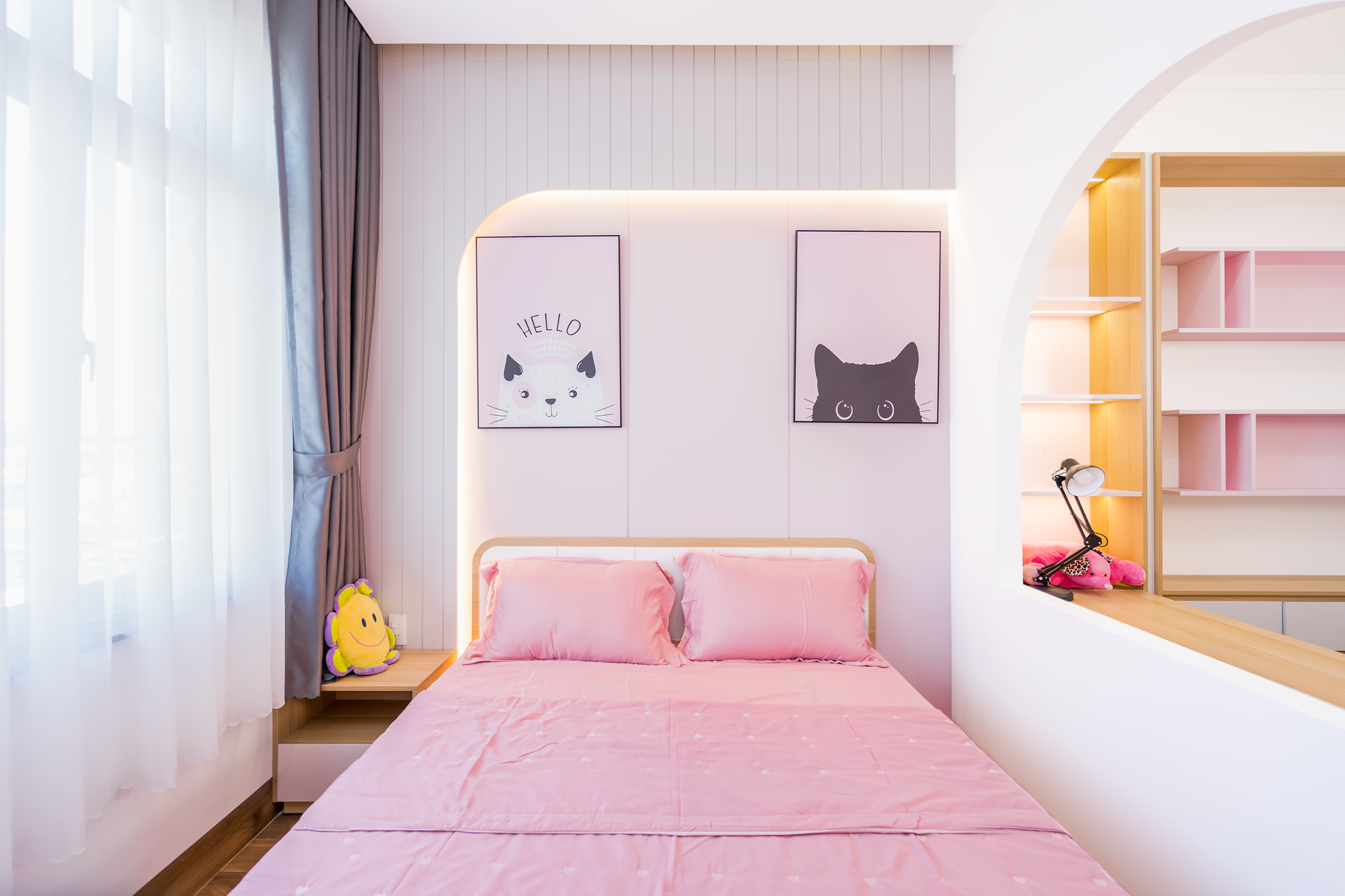 Bright bedroom interior with pink decor and playful cat art, perfect for a cheerful atmosphere.