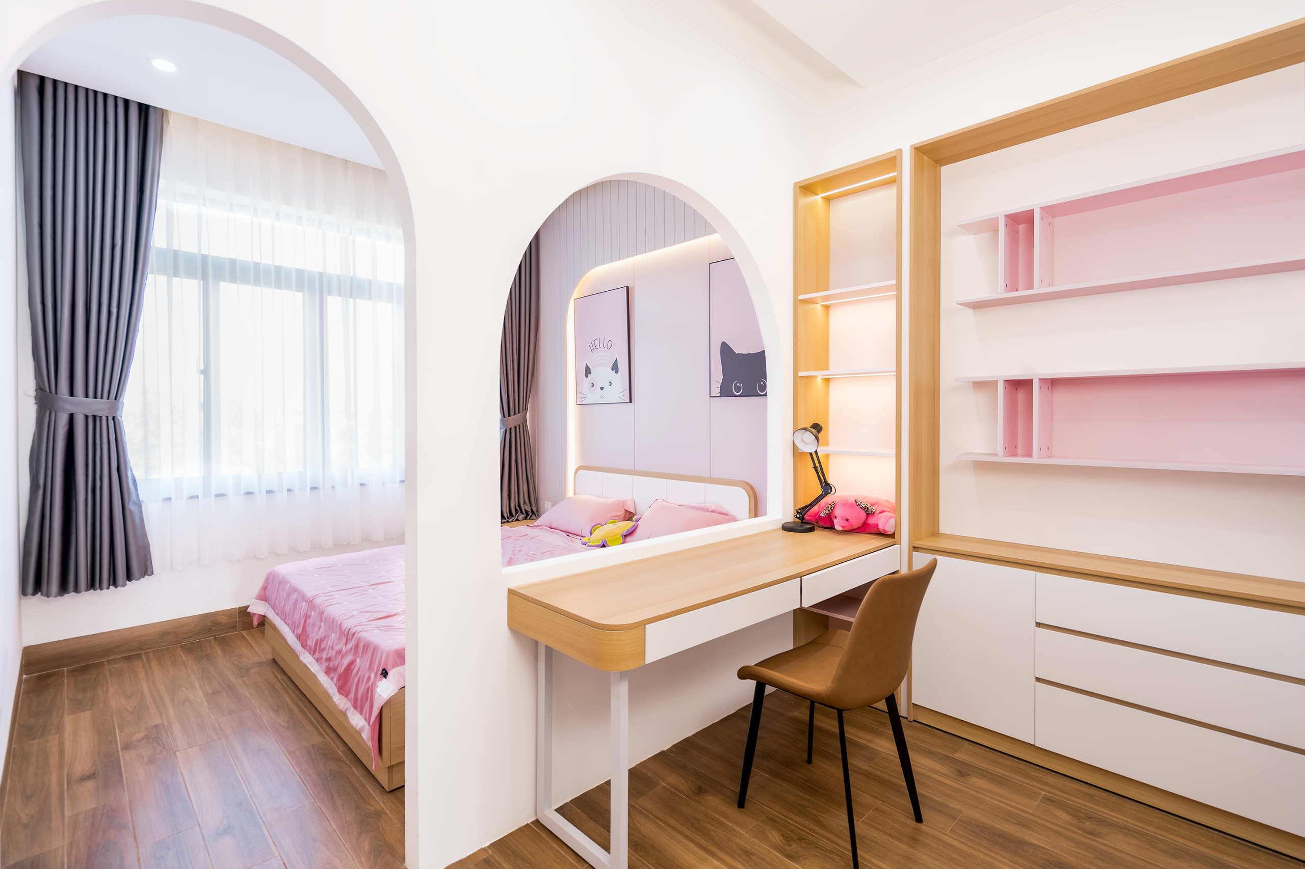 Bright, modern bedroom featuring a stylish pink workspace and cozy bed.