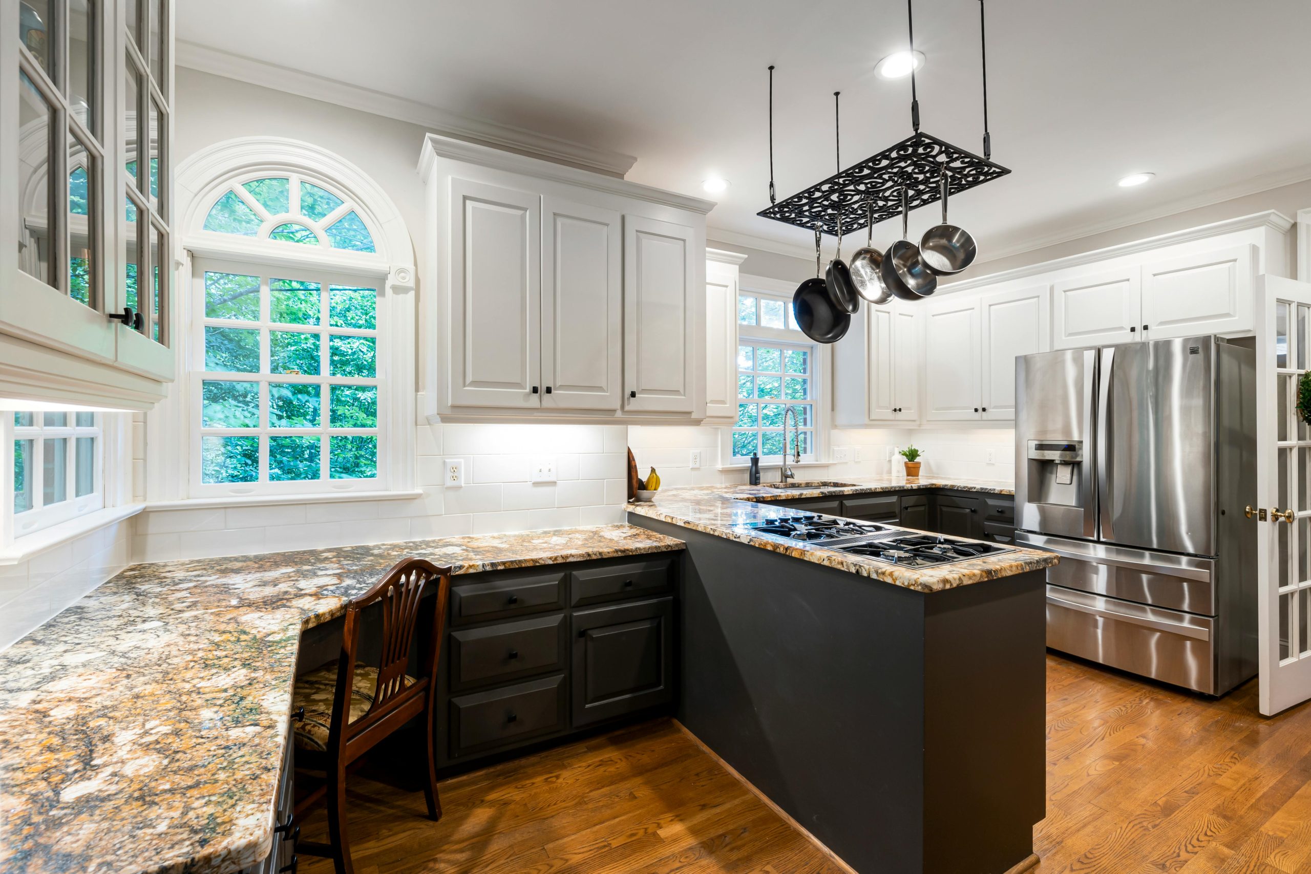 Bright modern kitchen with granite countertops, elegant cabinetry, and stainless steel appliances.