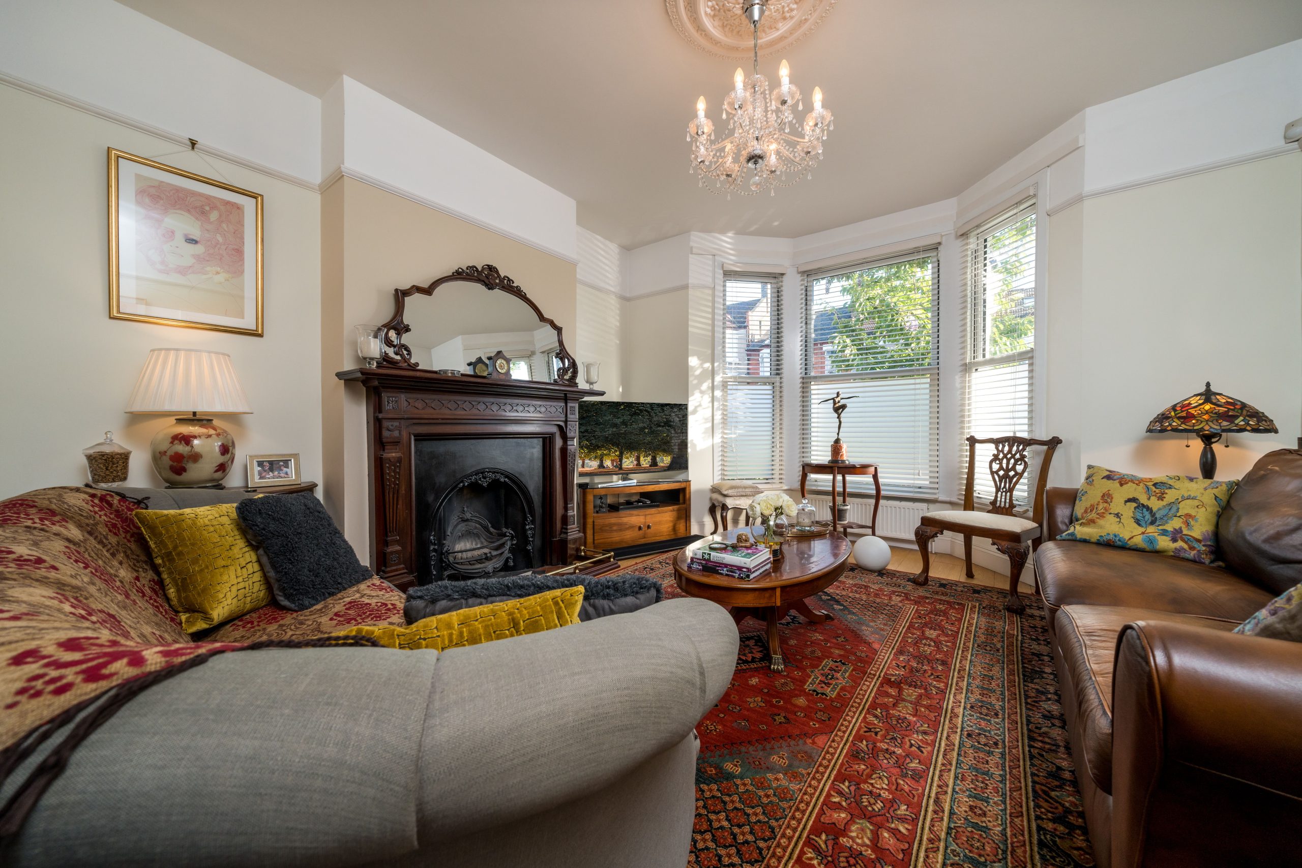 Charming living room with vintage decor, featuring plush sofas and a classic chandelier.
