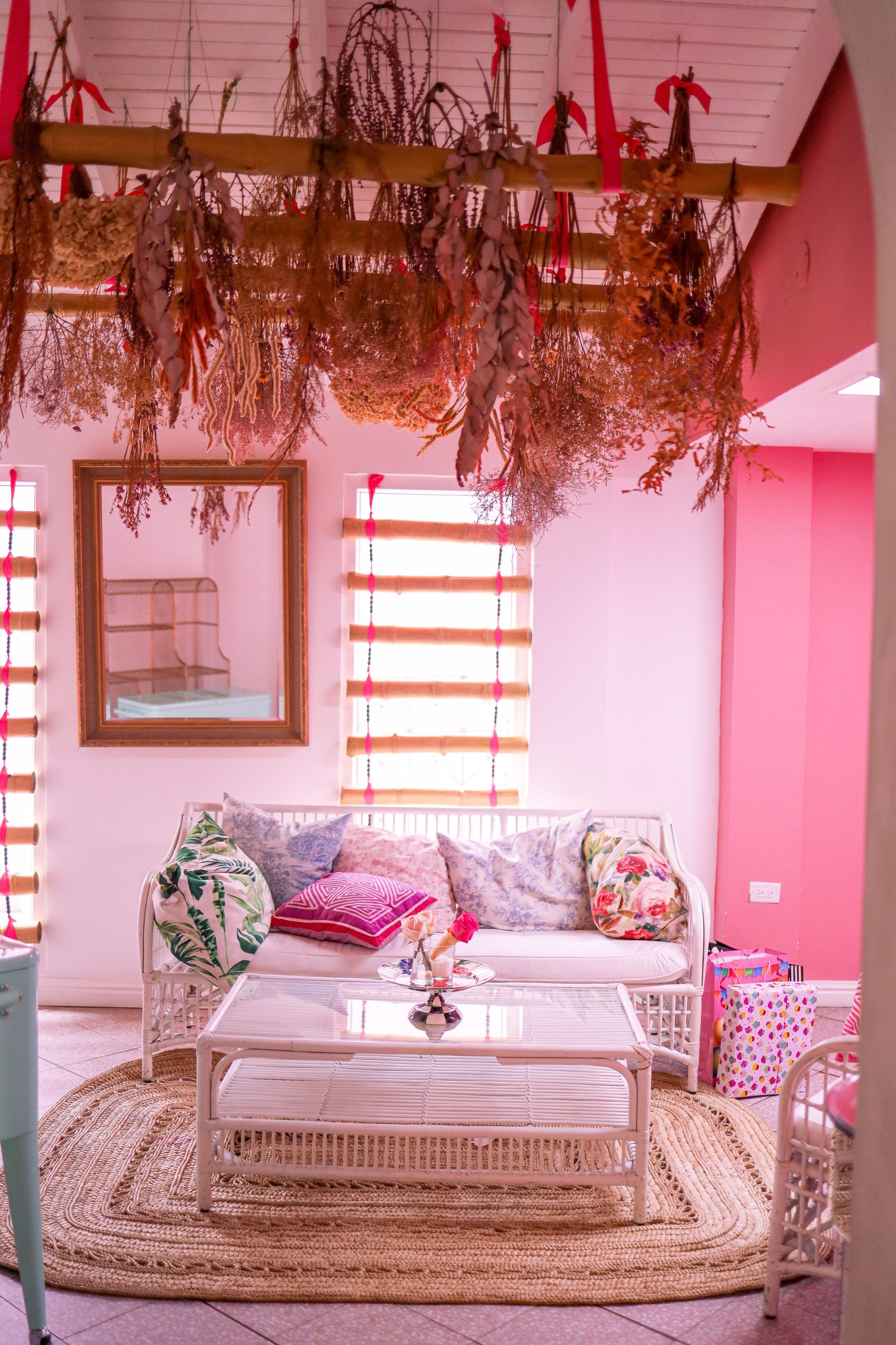 Charming pink living room with a white sofa and dried floral decor, perfect for modern home inspiration.