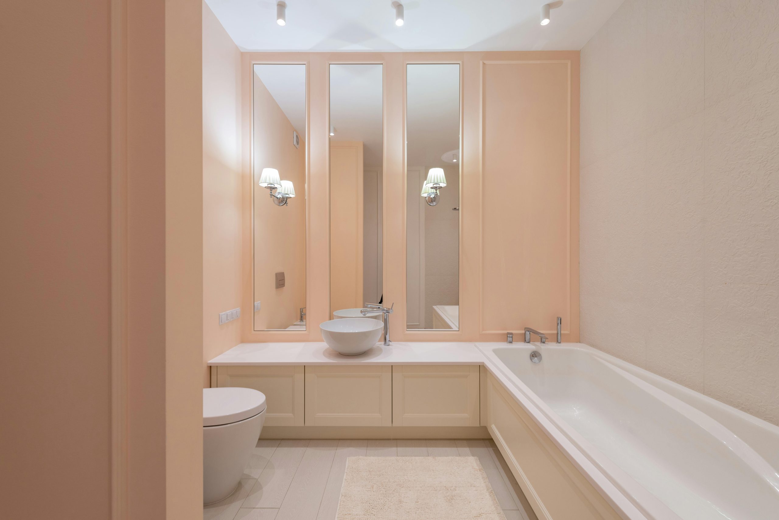 Clean light ceramic sink and bath placed in spacious bathroom with beige walls