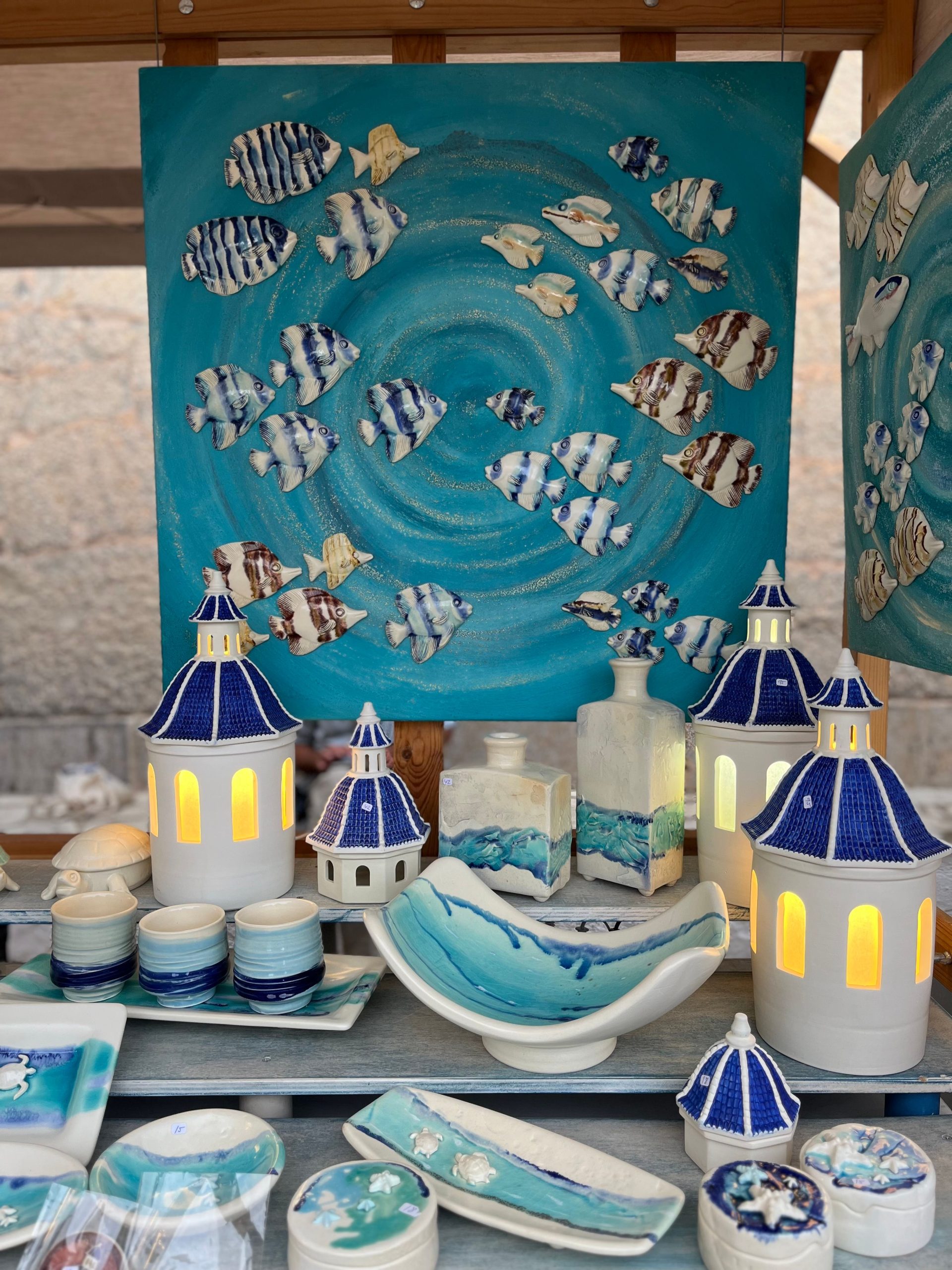 Colorful ceramic decor with fish and lighthouse motifs in a coastal art style.