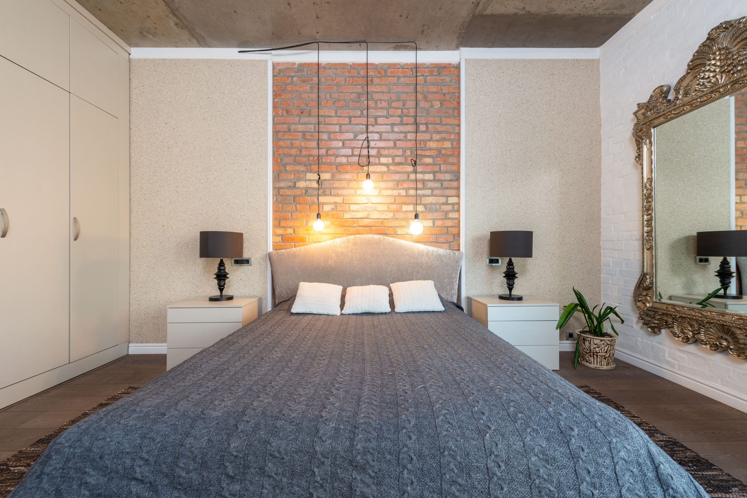 Contemporary bedroom featuring a stylish brick accent wall and elegant decor.