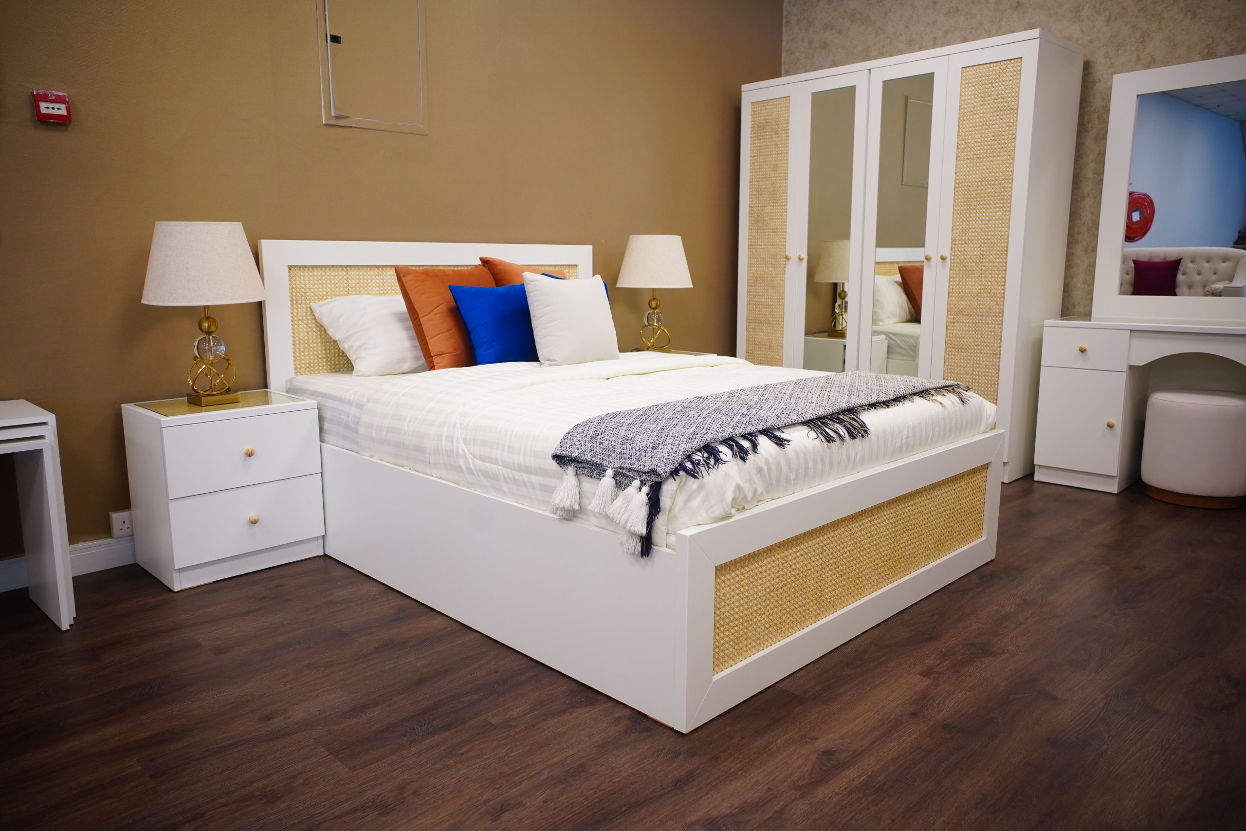 Elegant bedroom with modern white furniture, cozy textiles, and warm lighting.