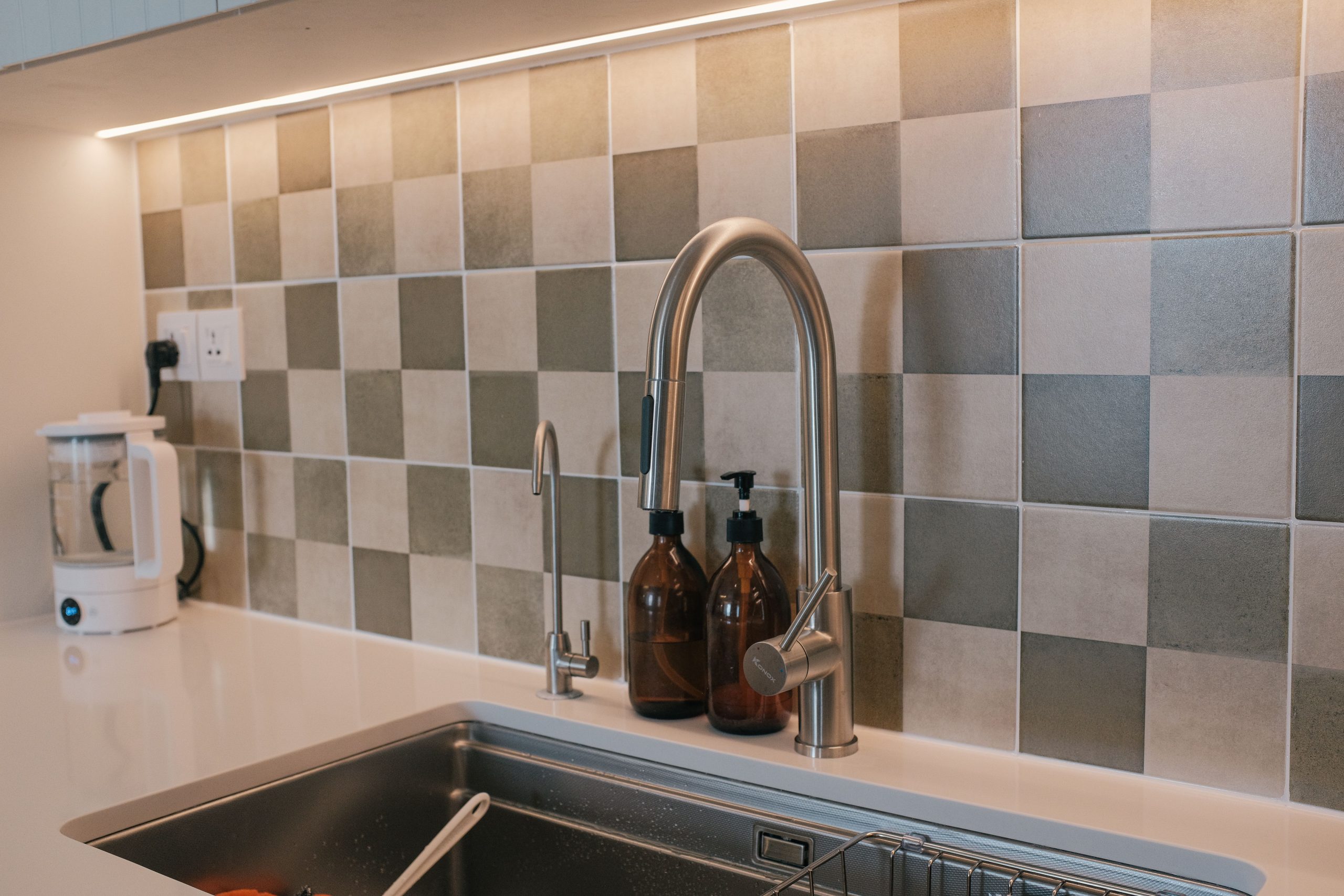 Elegant kitchen interior featuring a sleek faucet and tiled backsplash.