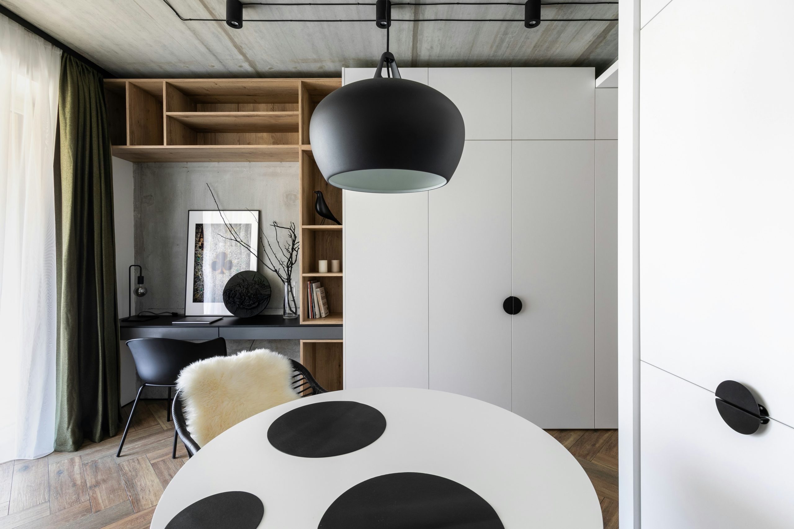he interior design of this small-area apartment is a masterful display of contrasts. The design's overarching theme revolves around the juxtaposition of black and white hues, resulting in a visually s