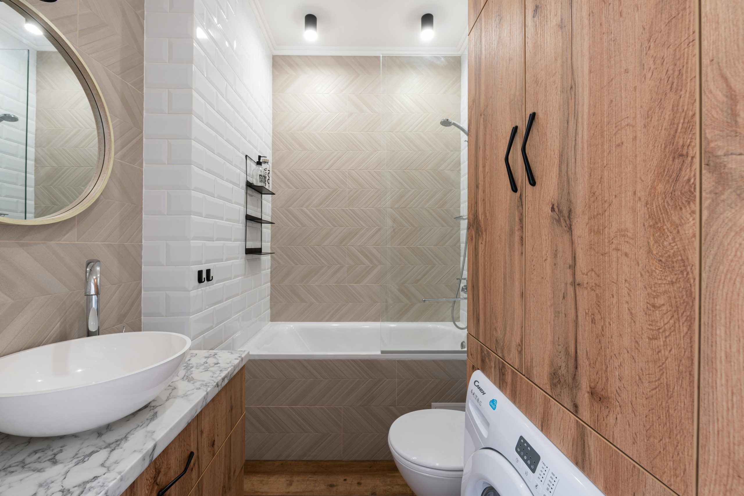 Modern interior of bathroom with clean white sink and wooden cabinets illuminated with bright lights