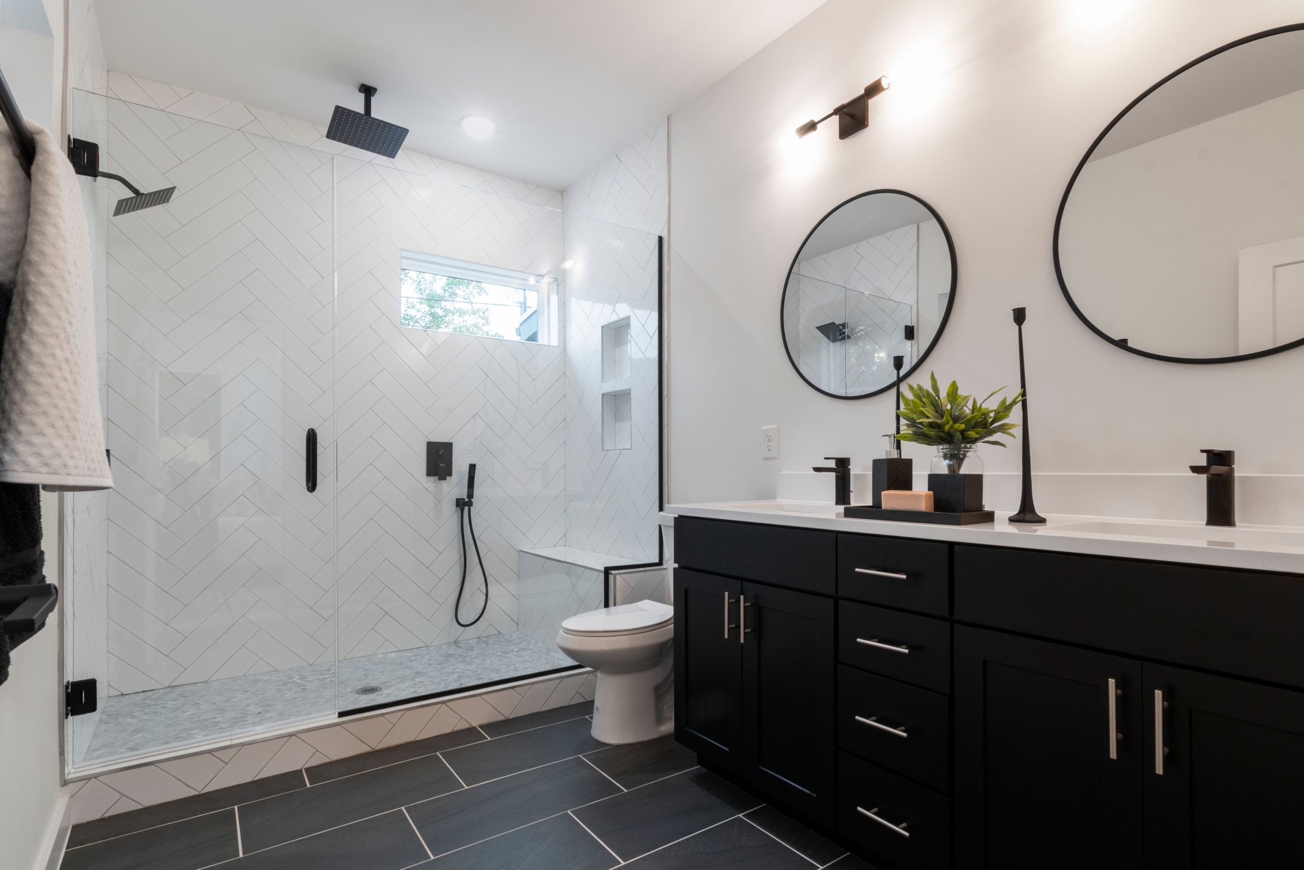 Stylish bathroom featuring a glass shower and elegant black vanity for a contemporary look.