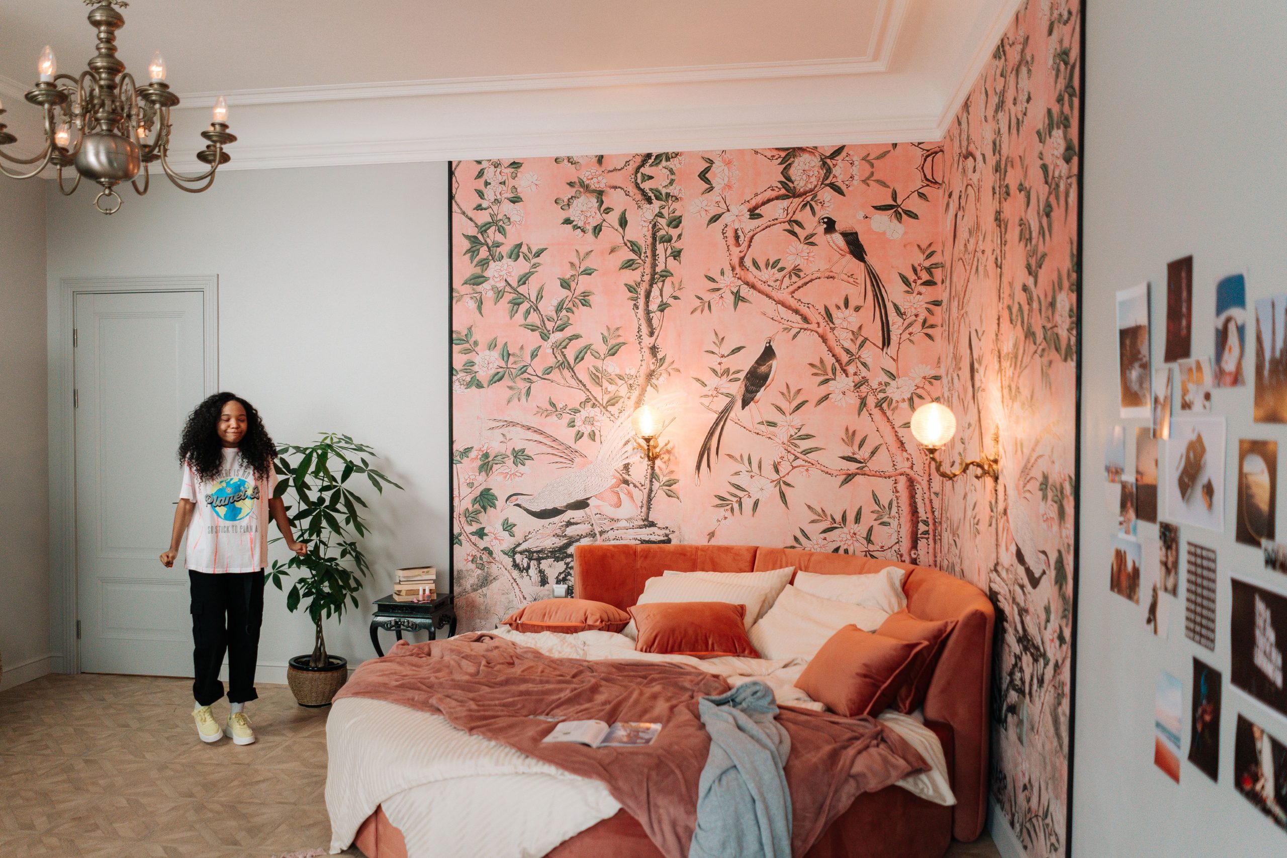 Stylish bedroom featuring a teenager, vibrant wallpaper, and eclectic decor.