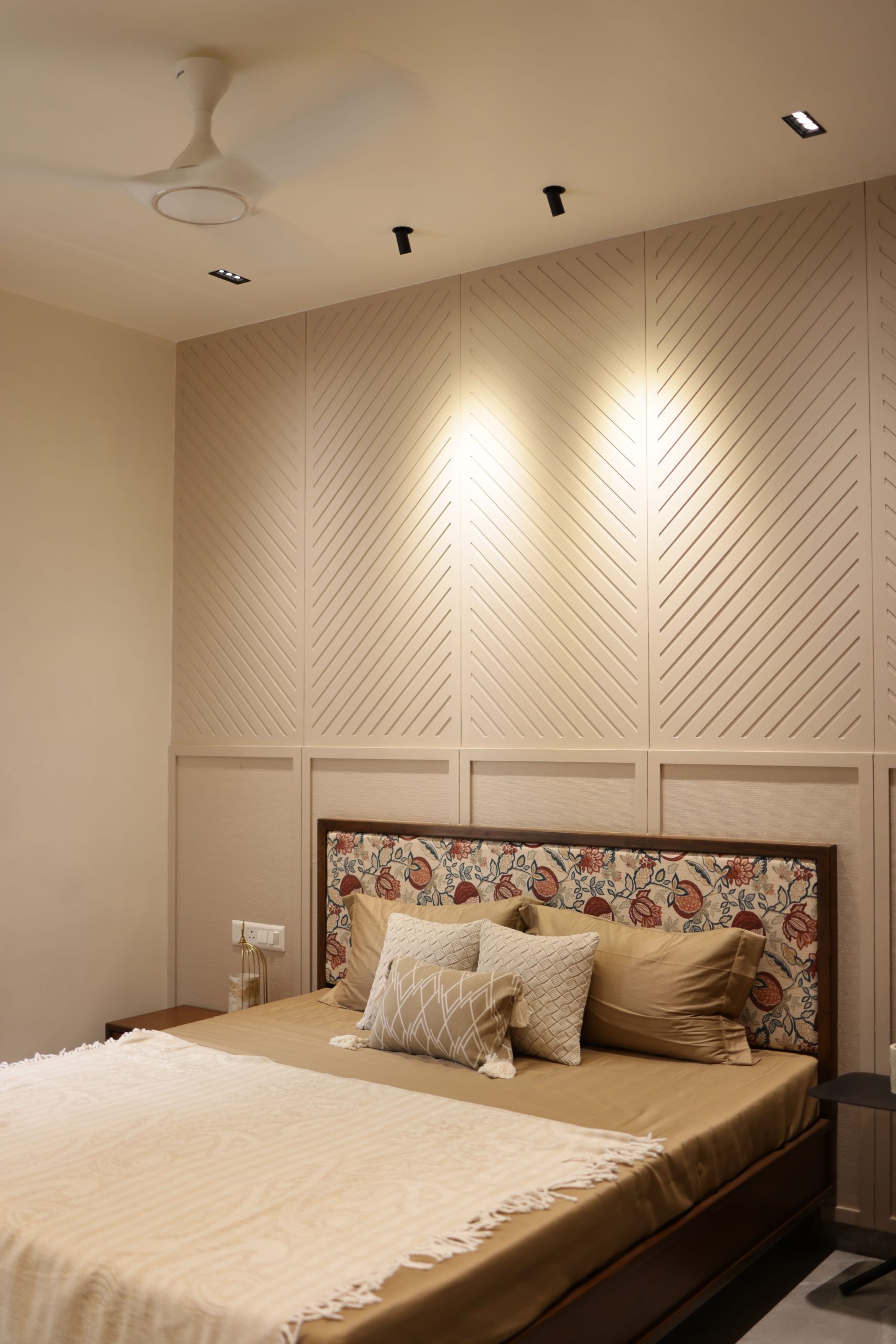 Stylish bedroom featuring beige tones and a patterned headboard, ideal for contemporary home decor.