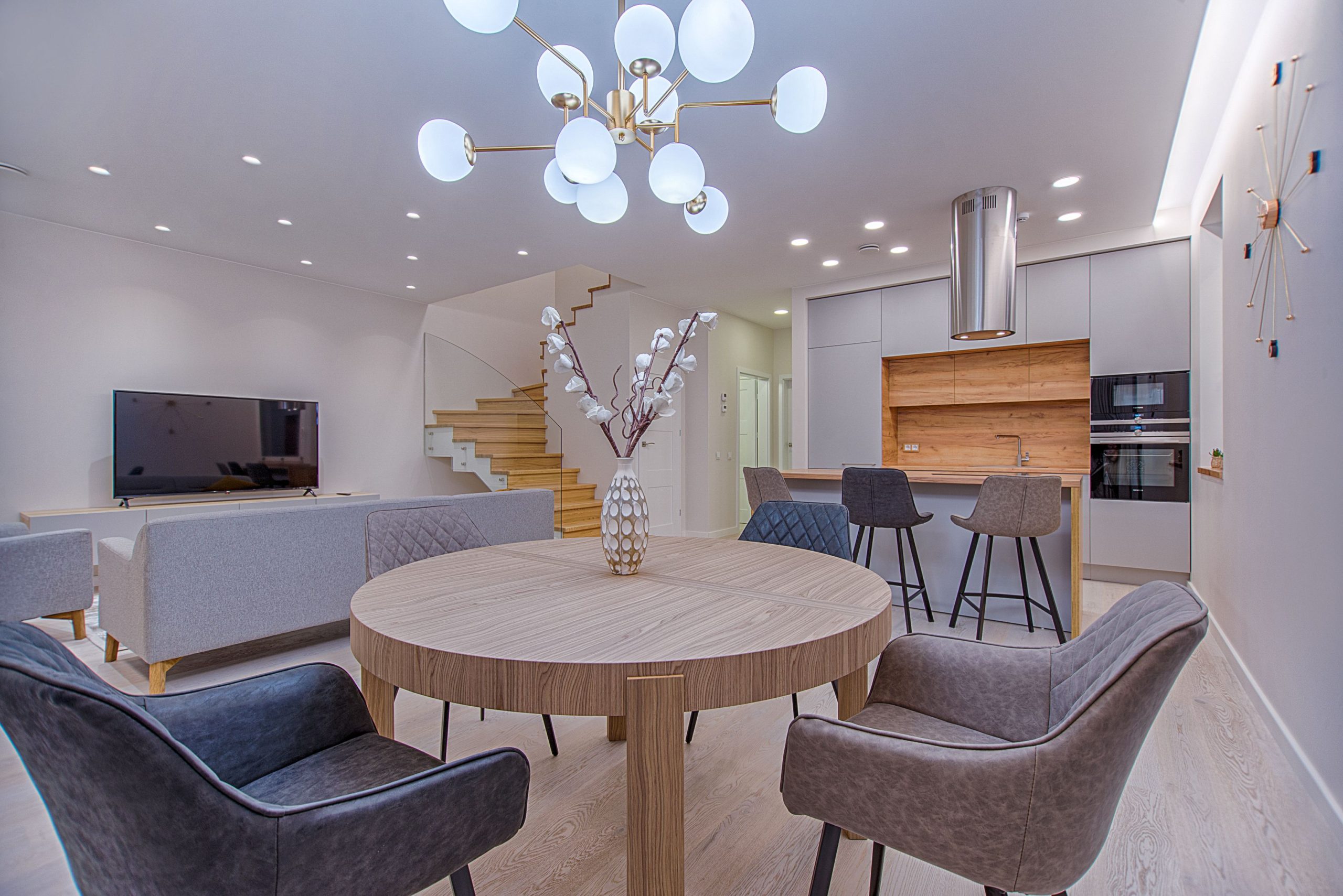 Stylish open-plan living room and kitchen with modern furnishings and lighting.