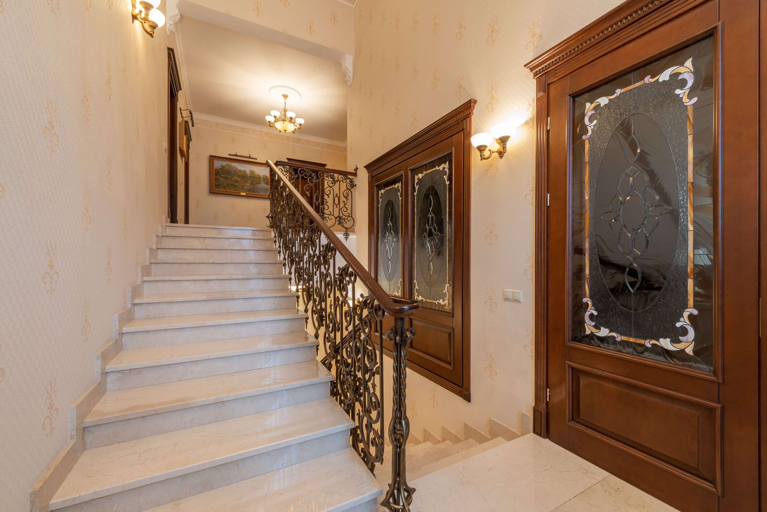 This elegant staircase features ornate railings and glass doors, creating a luxurious interior ambiance.