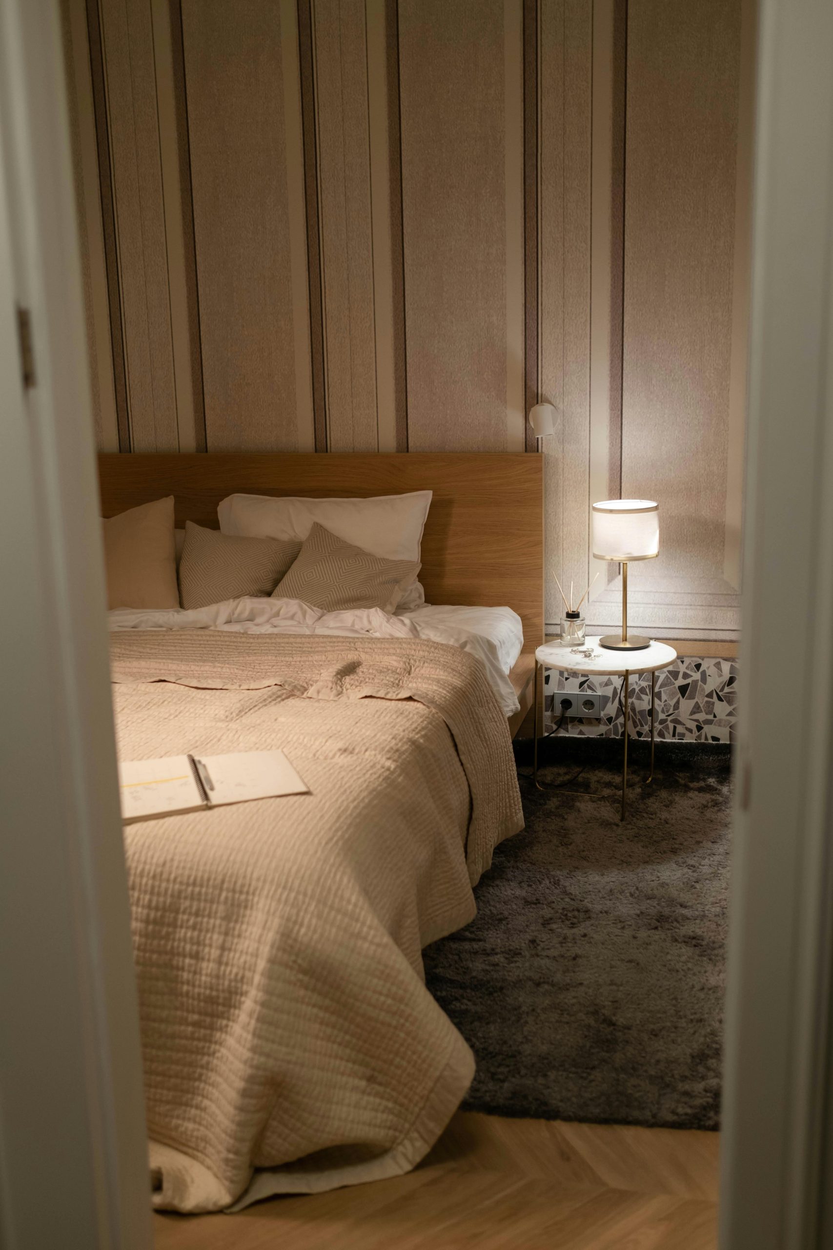 Warm and inviting bedroom with a wooden bed, soft lighting, and modern decor.
