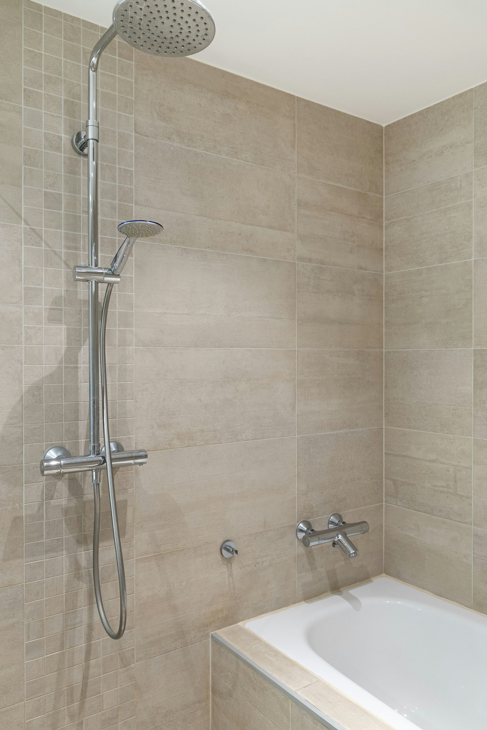 A bathroom with a tub and shower head