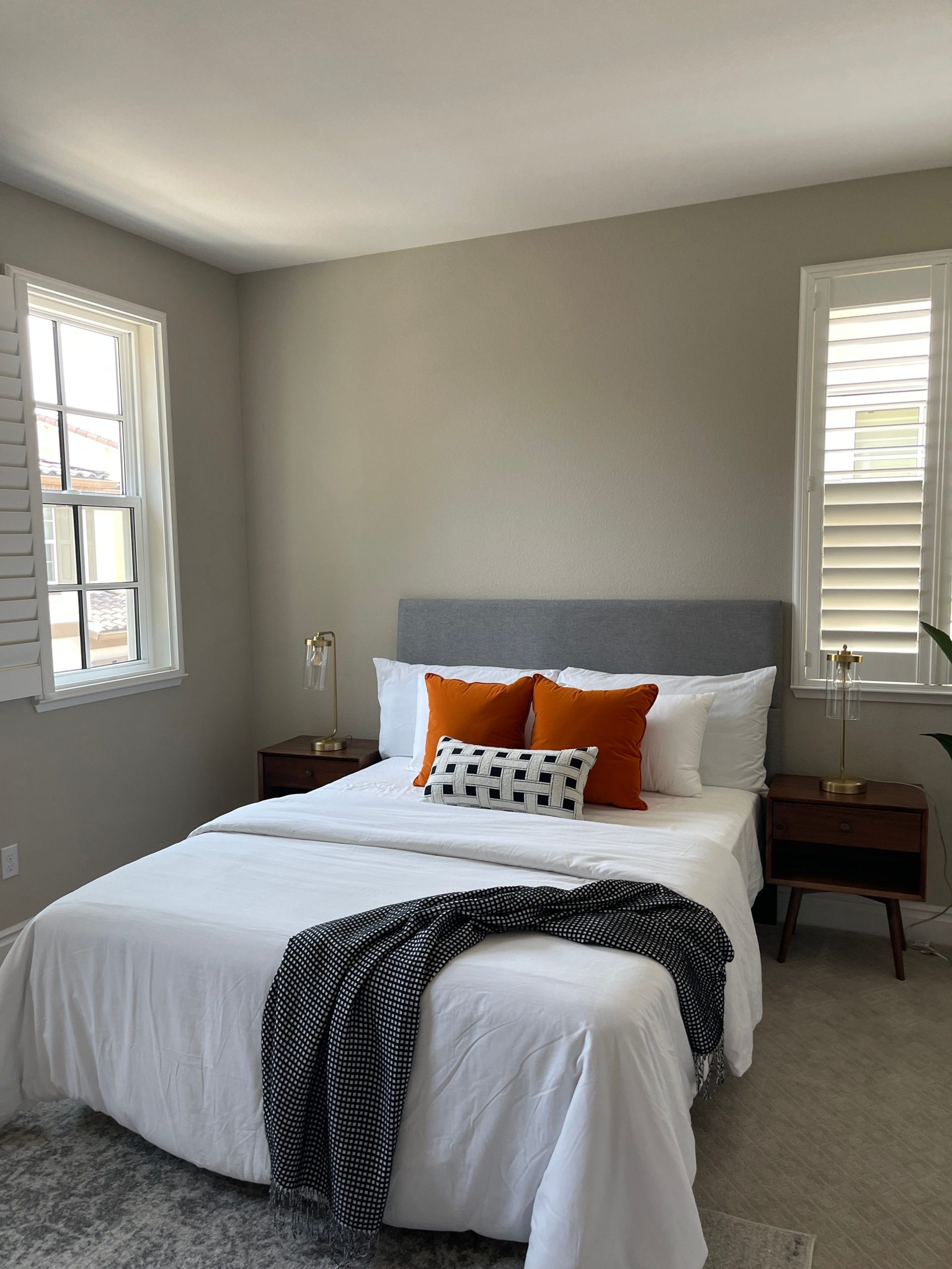 A modern bedroom interior featuring a cozy bed, vibrant pillows, and elegant decor.