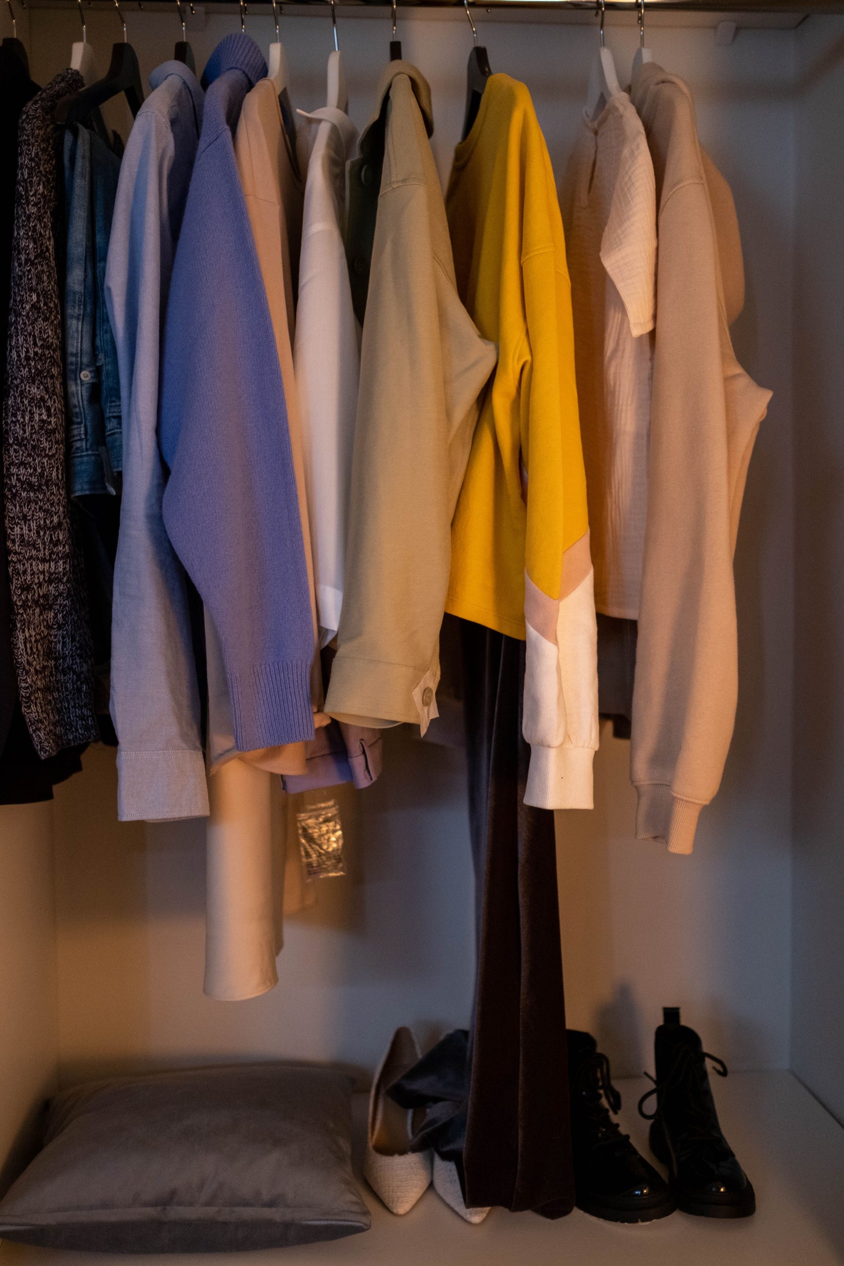 A stylish collection of clothes and shoes neatly arranged in a closet.