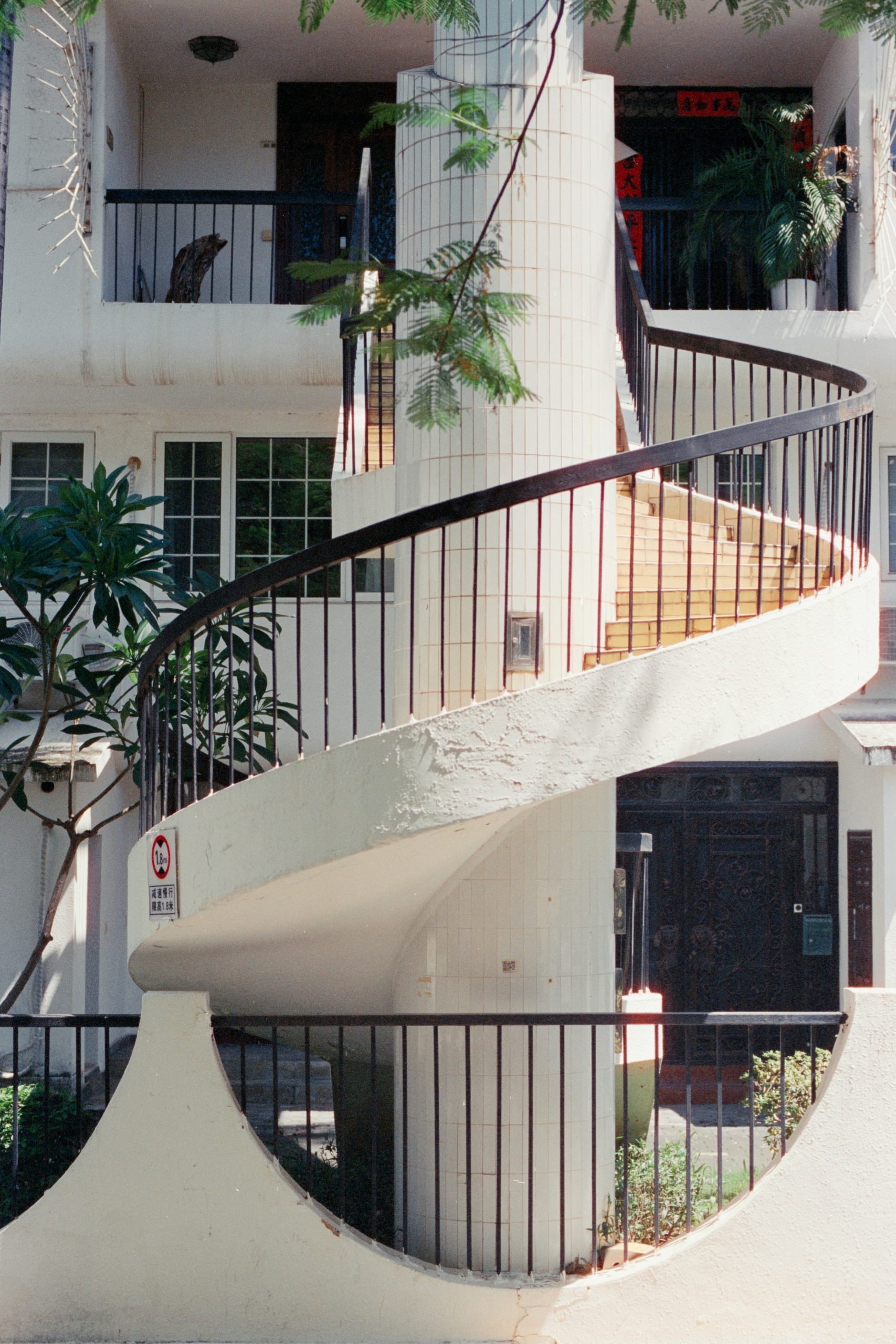 A white spiral staircase with black railings outdoors.