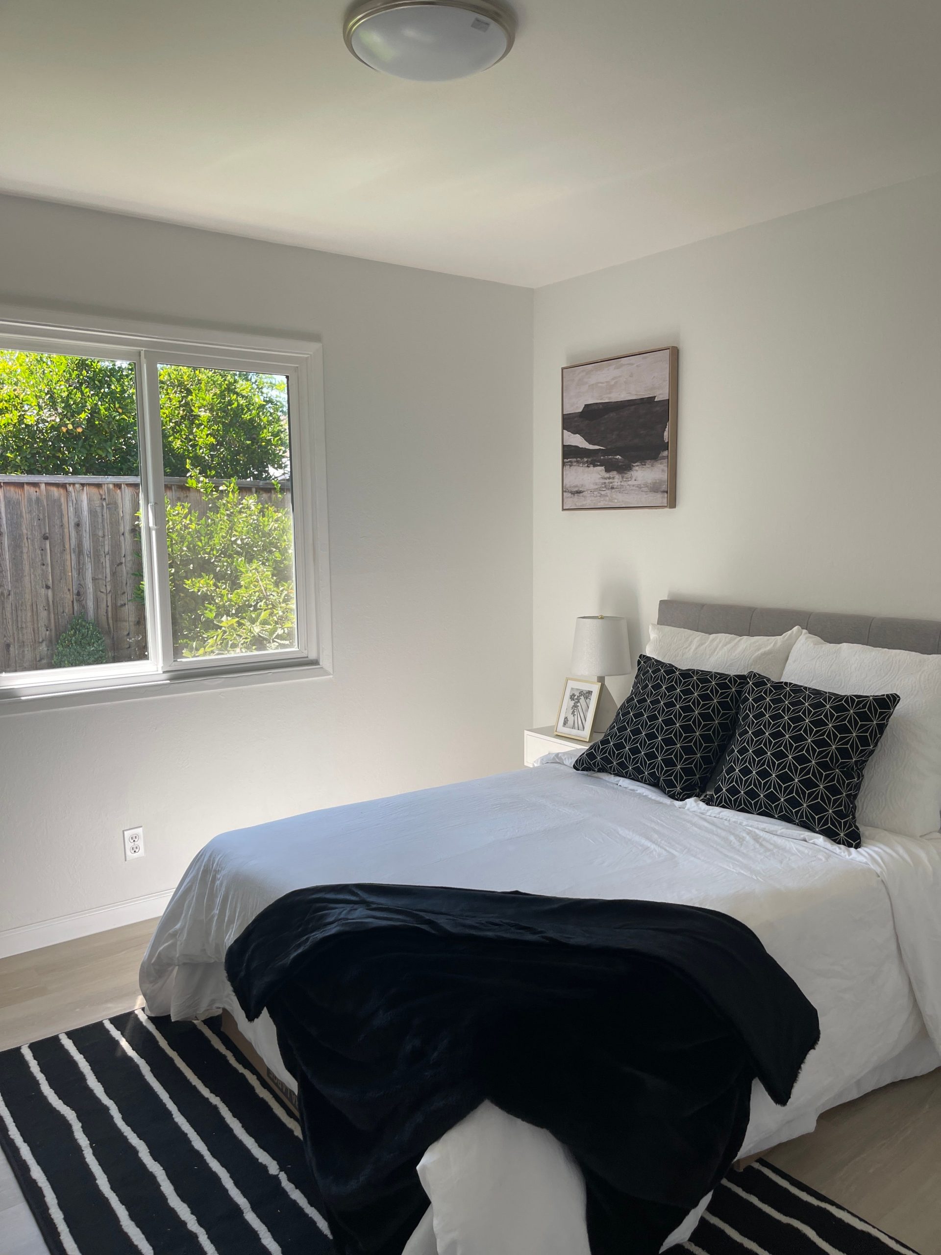 Bright and minimalistic bedroom interior featuring a cozy bed and natural light.
