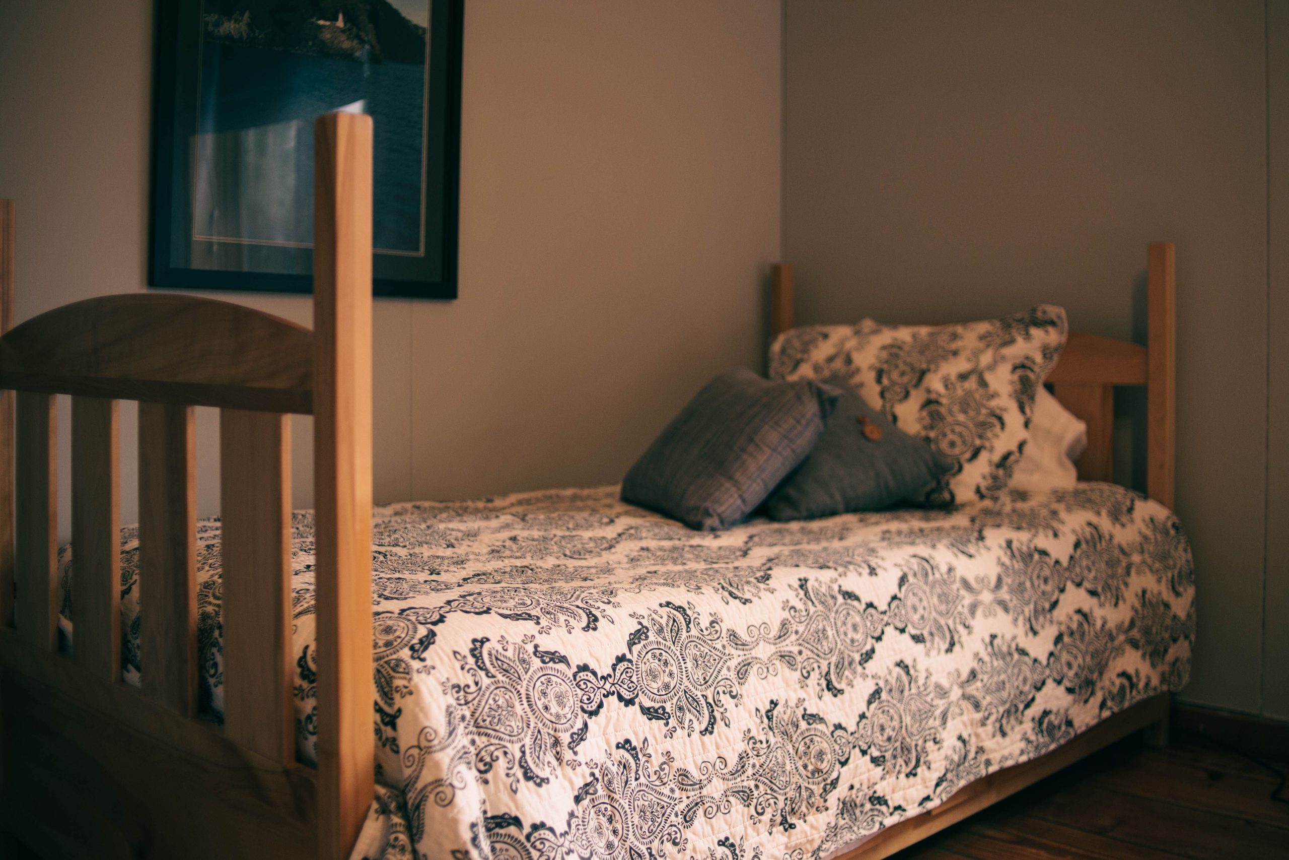 Charming bedroom interior featuring a wooden bed with decorative quilt and pillows.