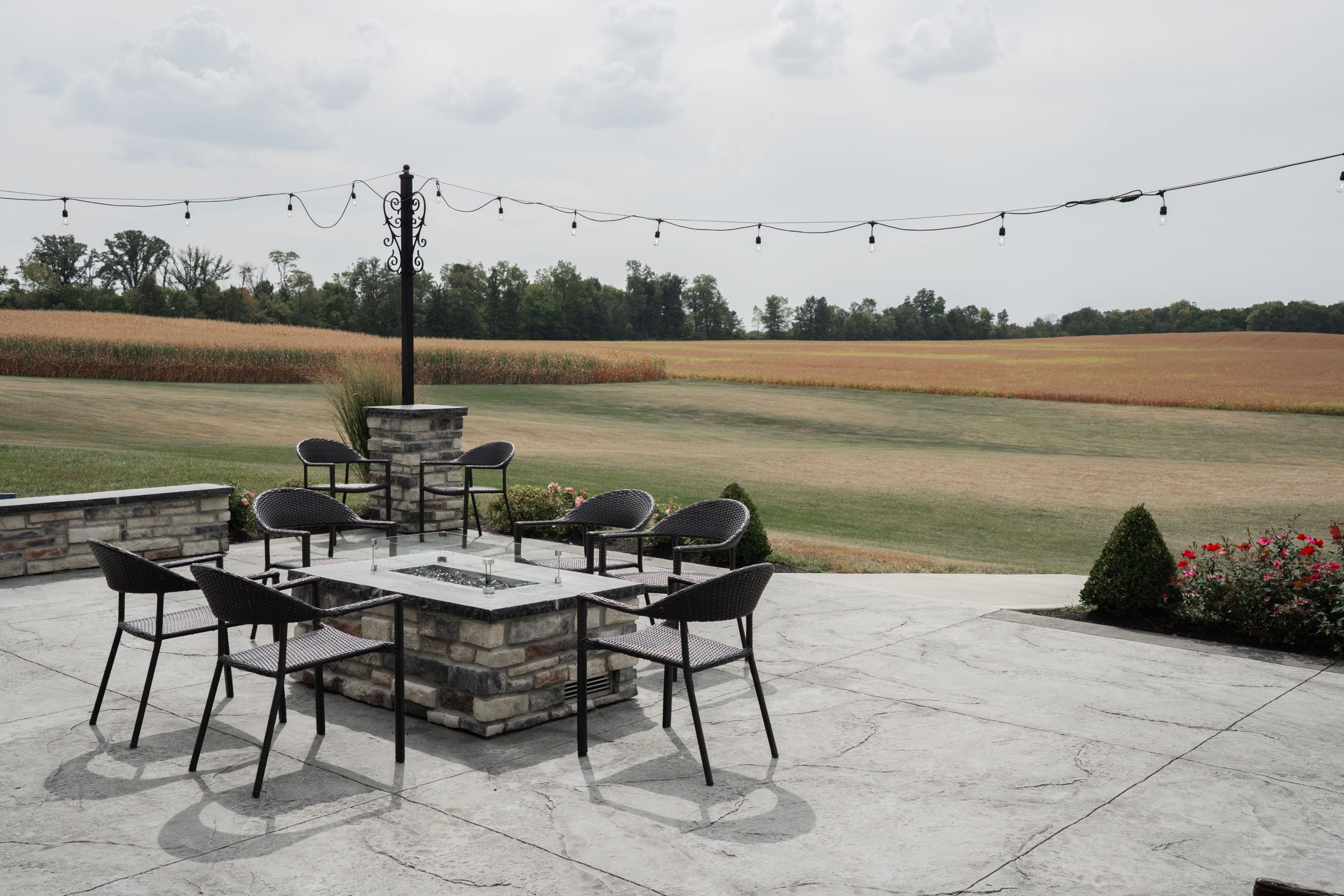 Charming outdoor patio with seating and countryside field view, perfect for relaxation.