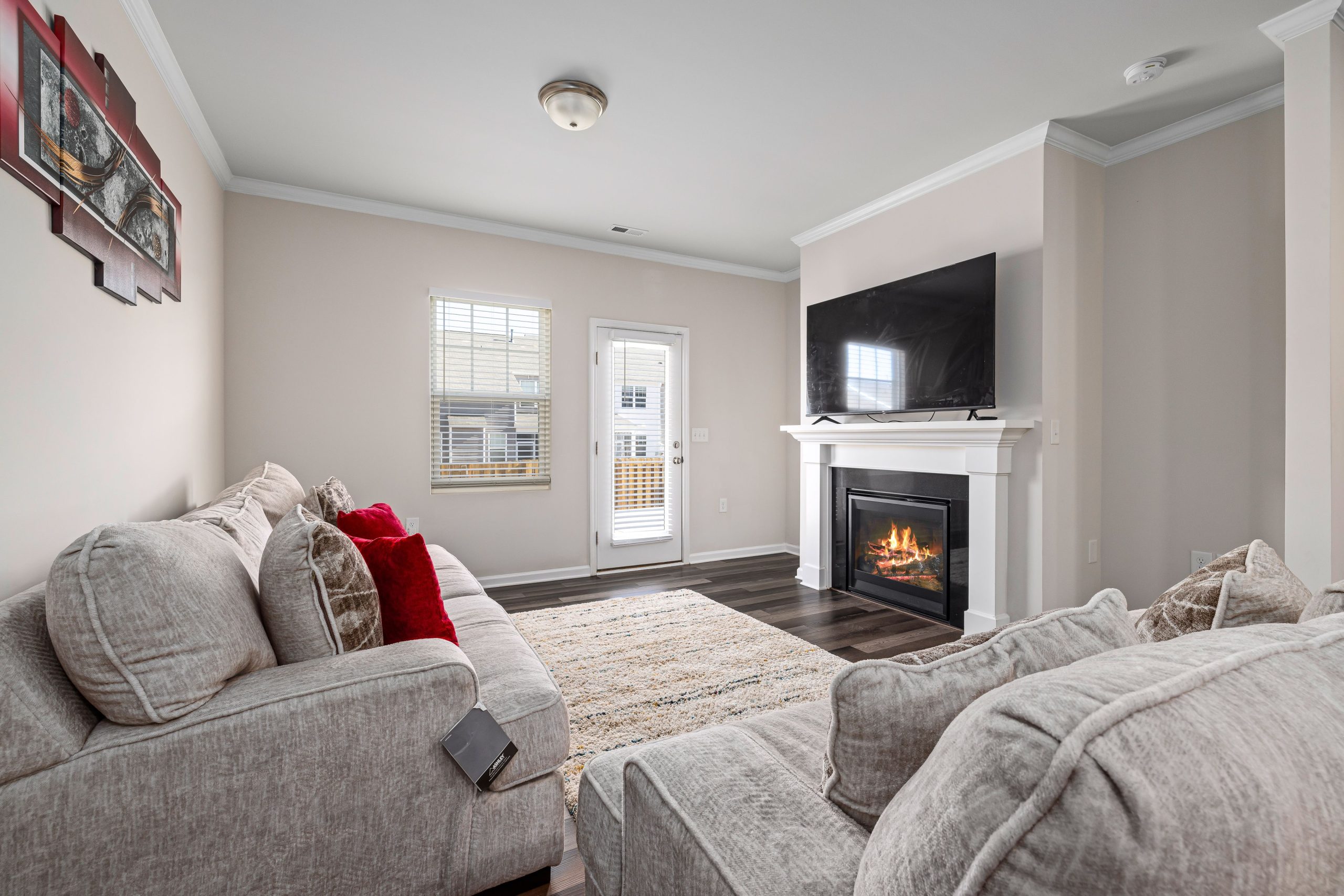 Cozy modern living room featuring a stylish fireplace and large TV for ultimate relaxation.