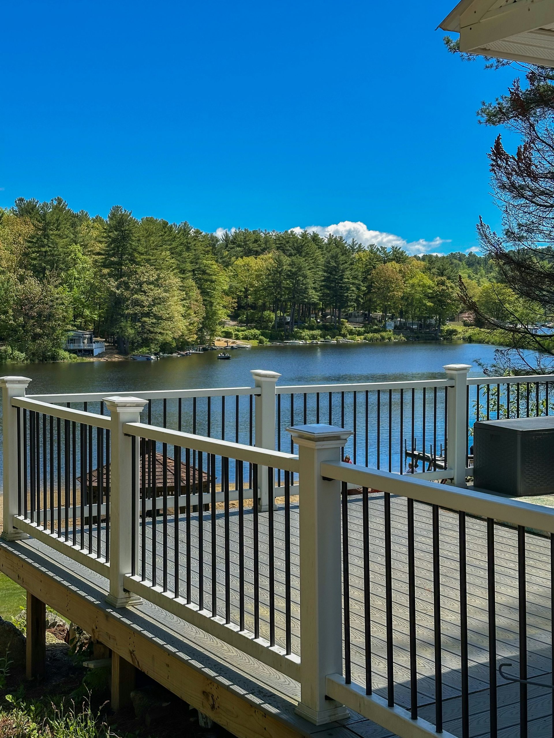 Deck overlooking a serene lake surrounded by trees