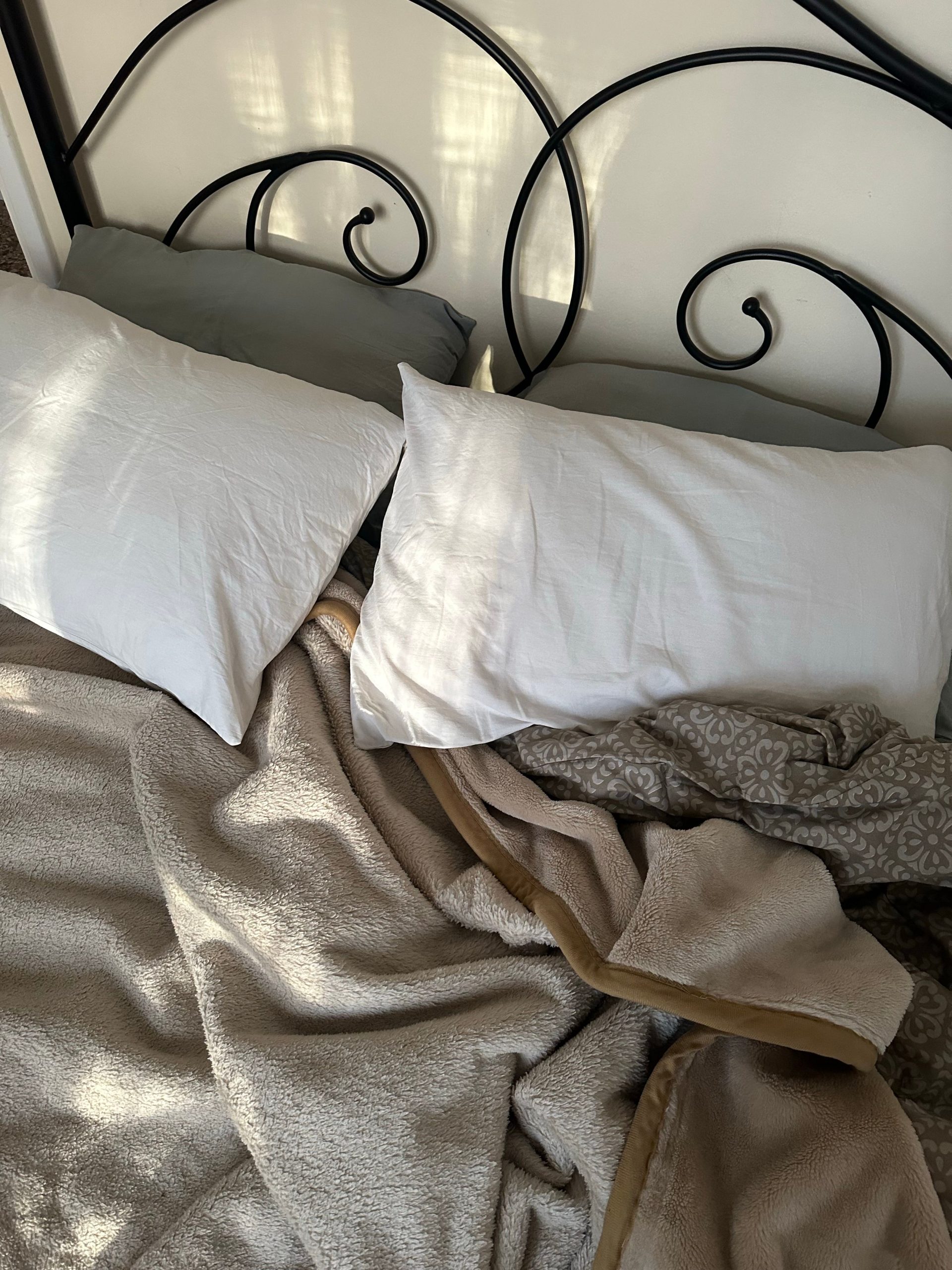 Inviting bed with soft blankets and pillows, perfect for a cozy home atmosphere.
