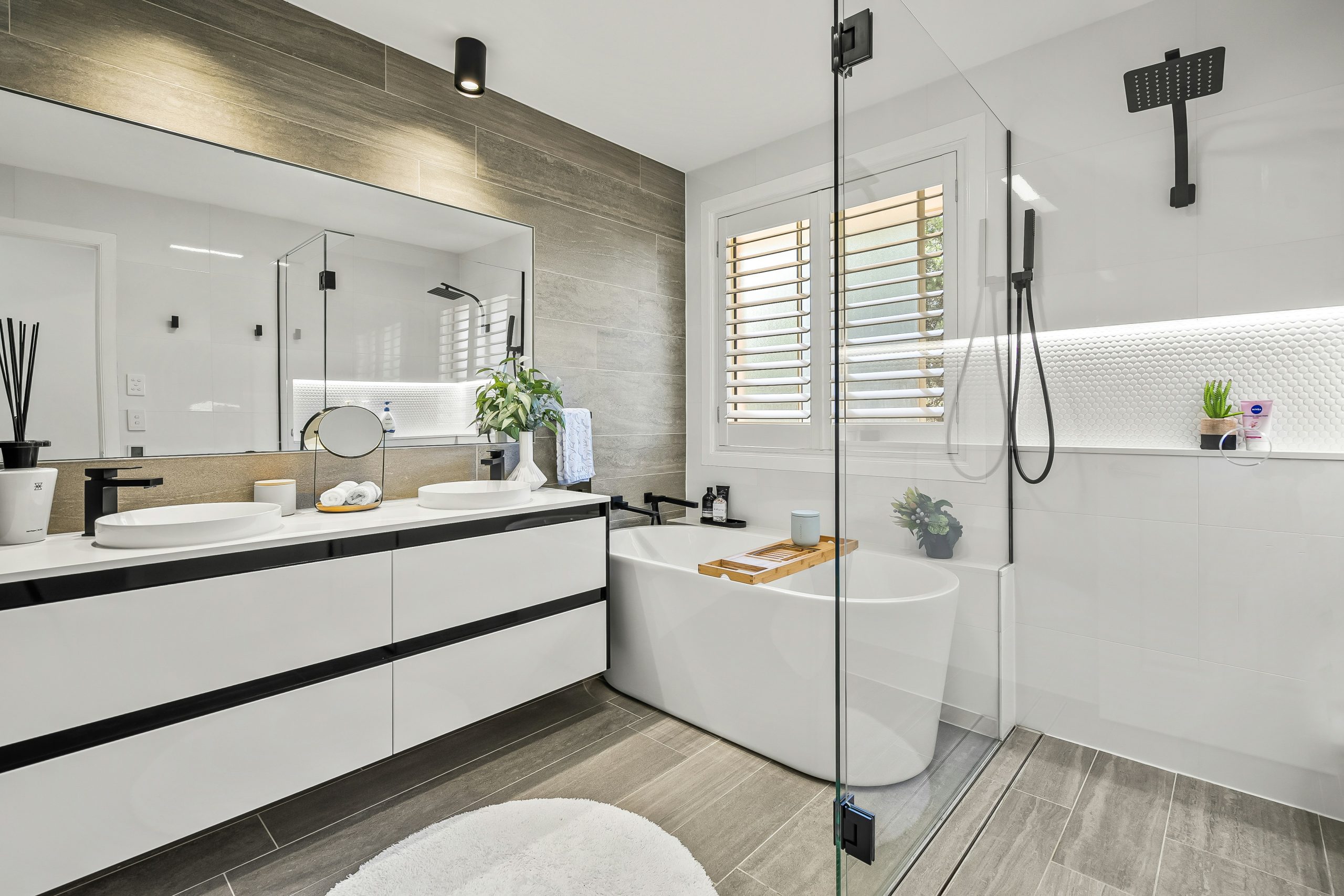 Luxurious modern bathroom with double vanity and freestanding bathtub.