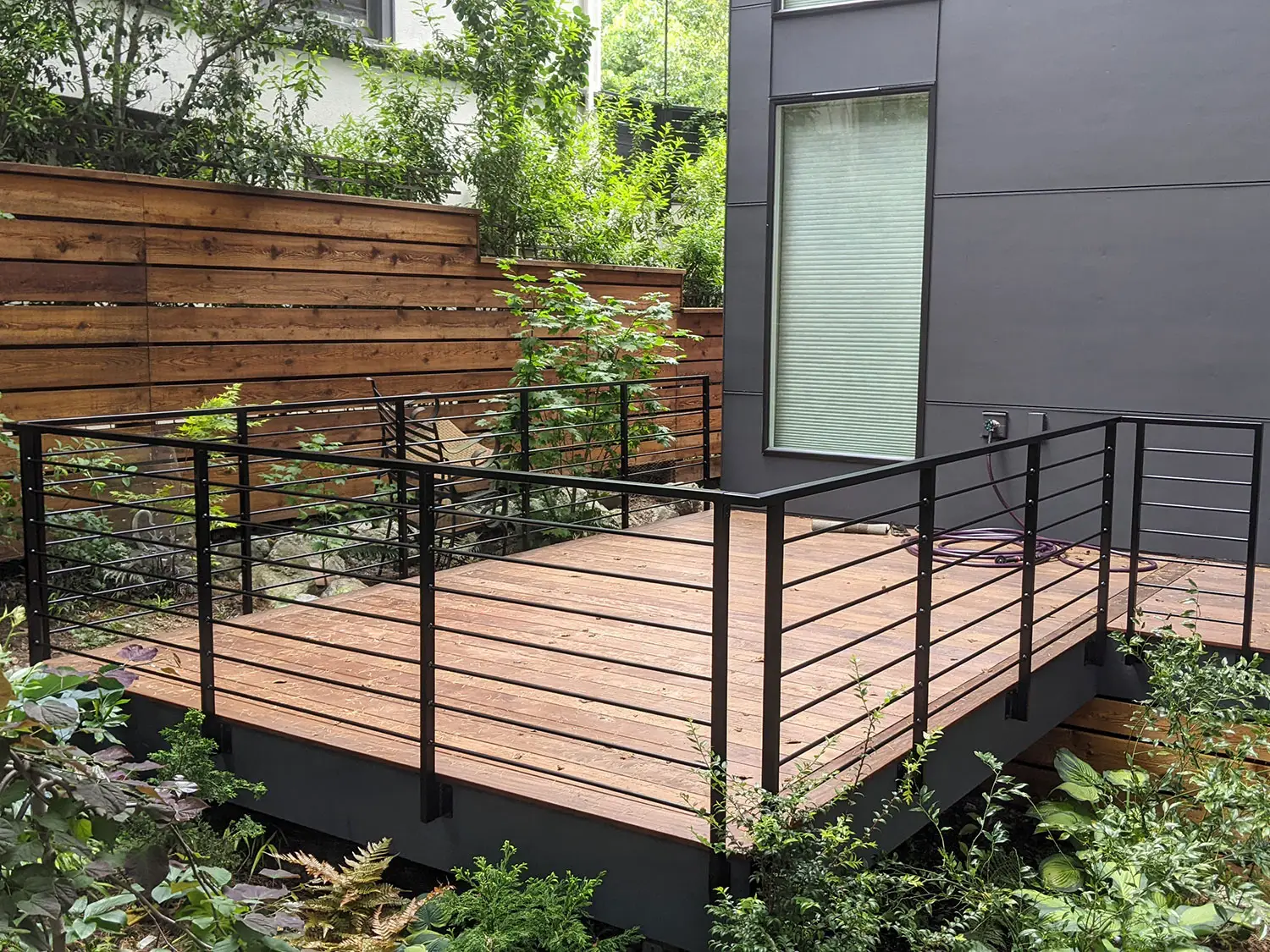 Modern horizontal deck railing with round bar infill - Blackbird Iron & Design