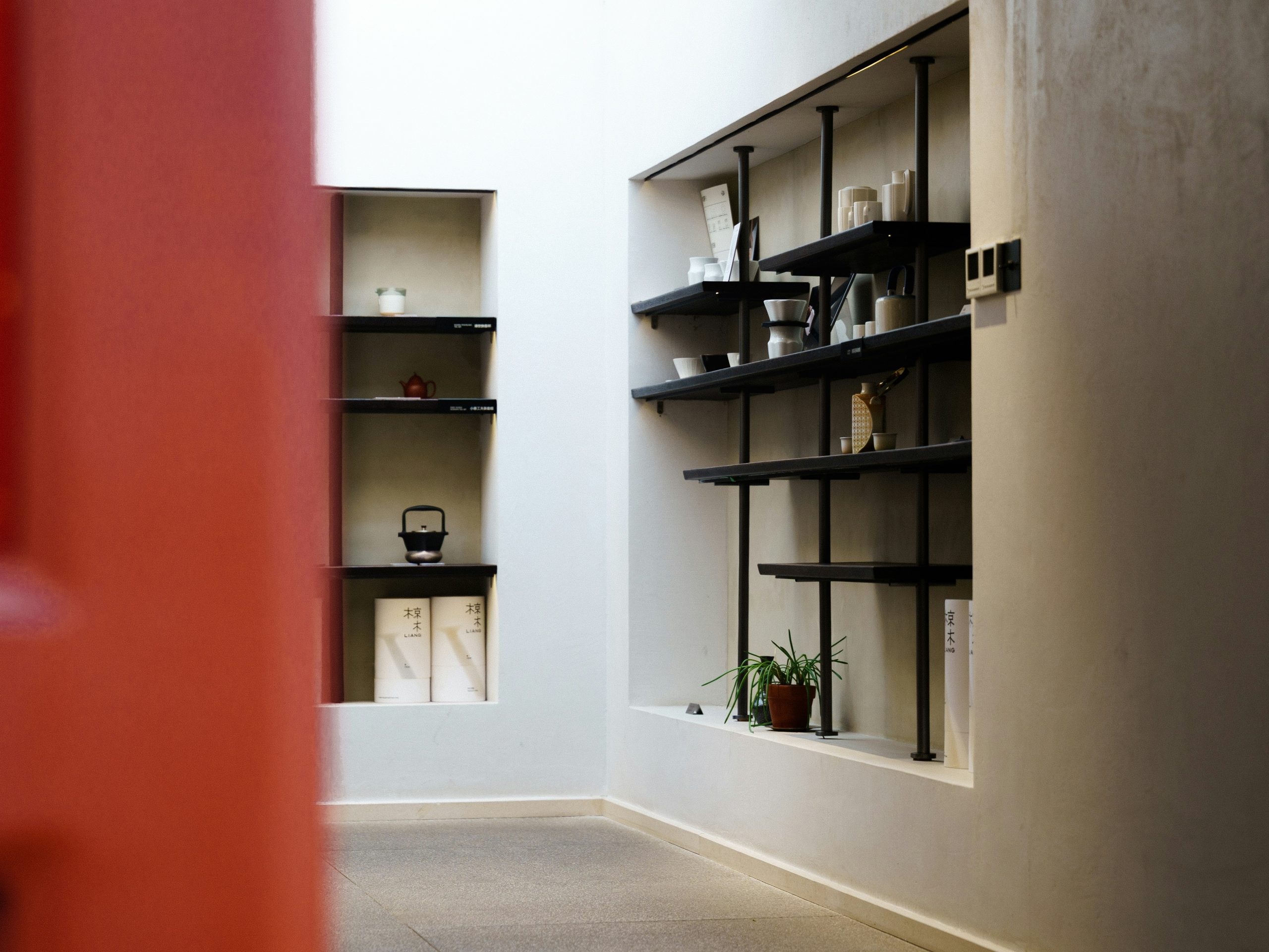 Modern interior with black industrial shelves and recessed wall displays.