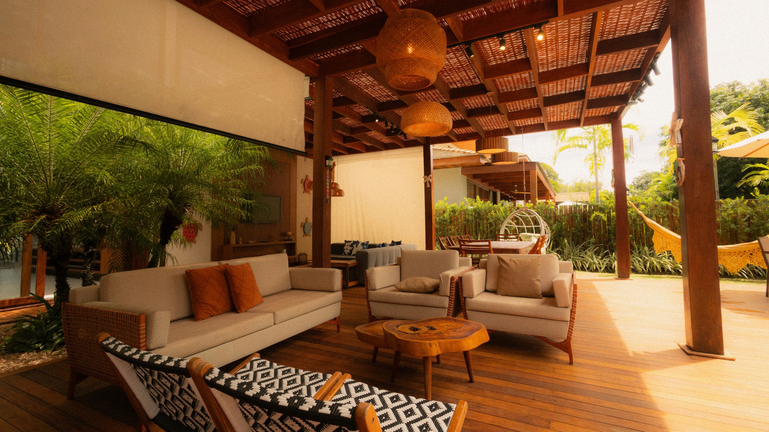 Outdoor living space with sofas and hanging chairs.