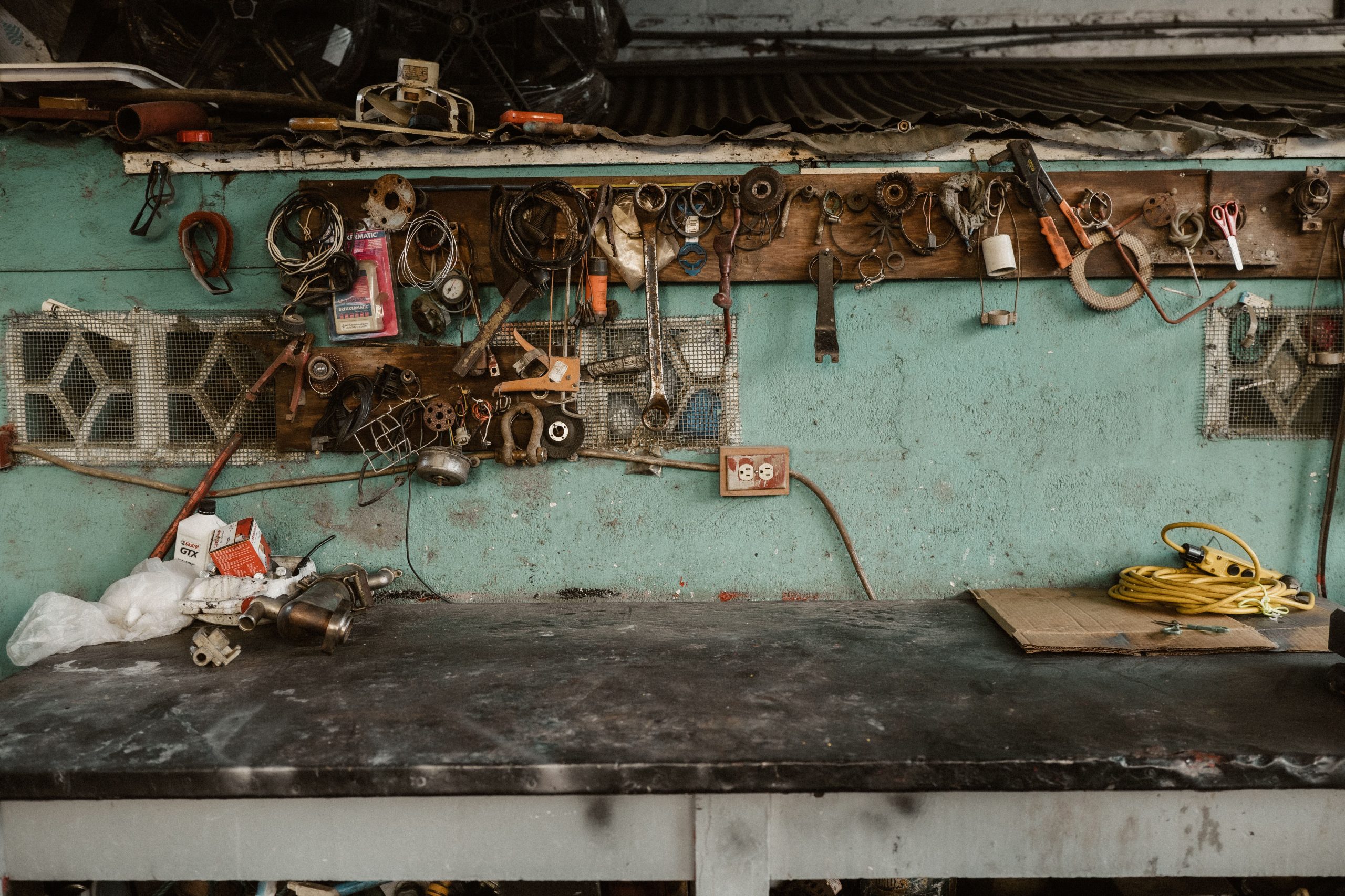 Rustic workshop scene with tools and accessories arranged on a wall rack.