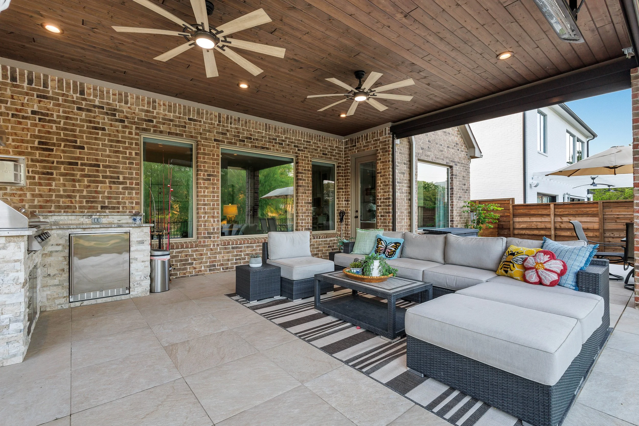 Seamless Rockwall Patio Cover with Outdoor Kitchen, Porcelain Pavers & Scenic Pond View