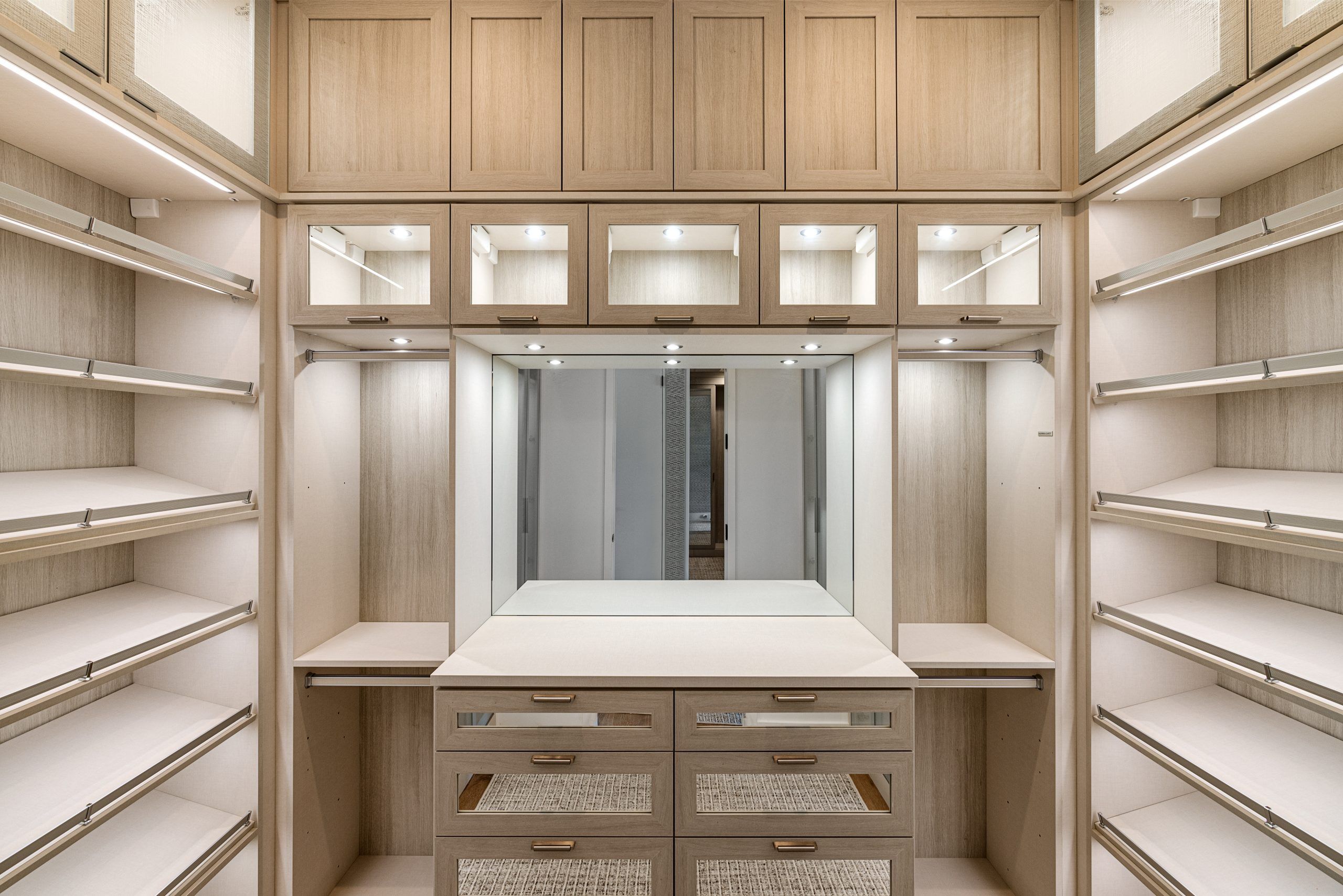 Spacious walk-in closet with wooden cabinets and ample lighting.