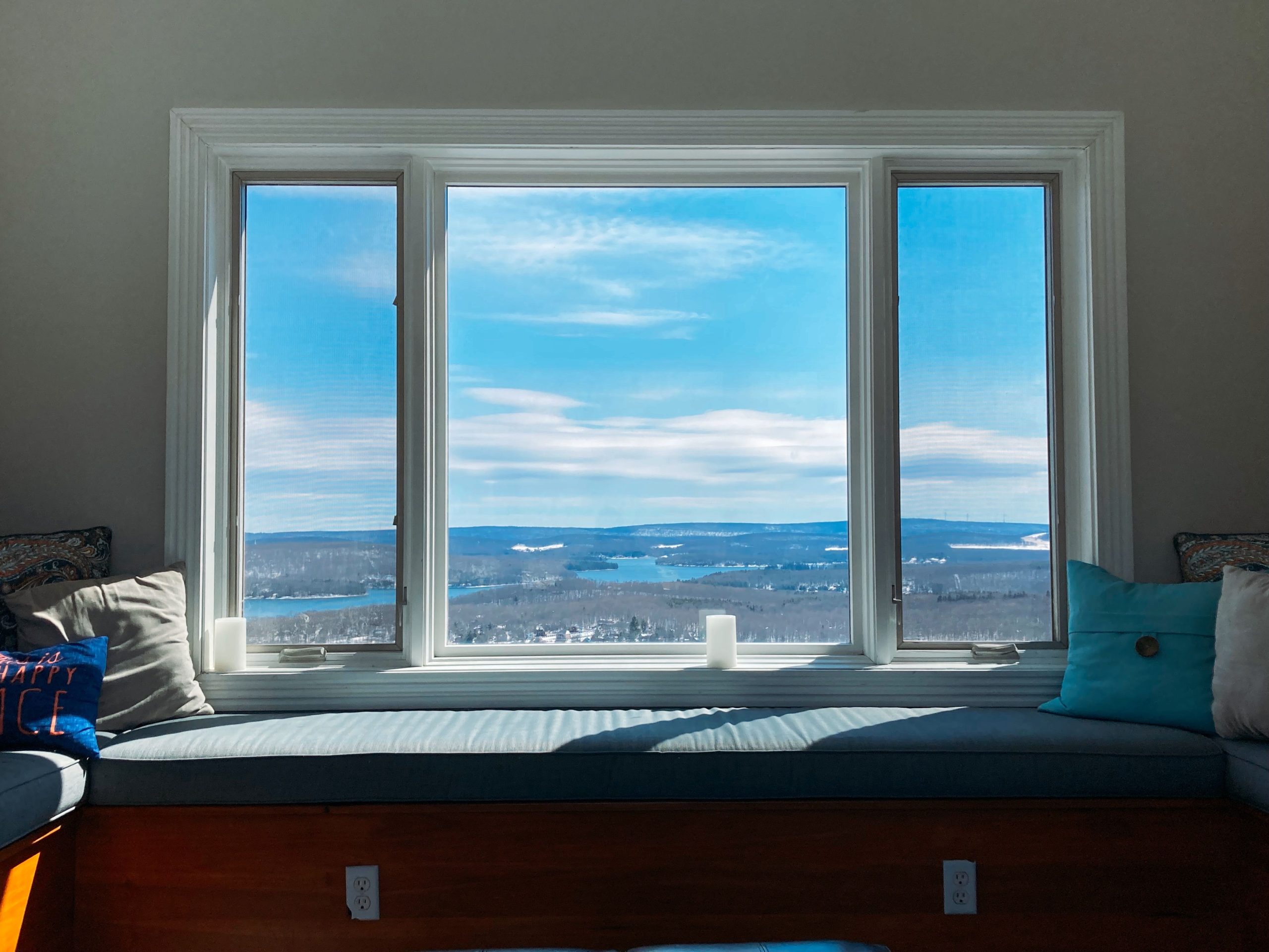 A comfortable indoor window seat overlooking a vast scenic landscape with blue skies in Maryland.